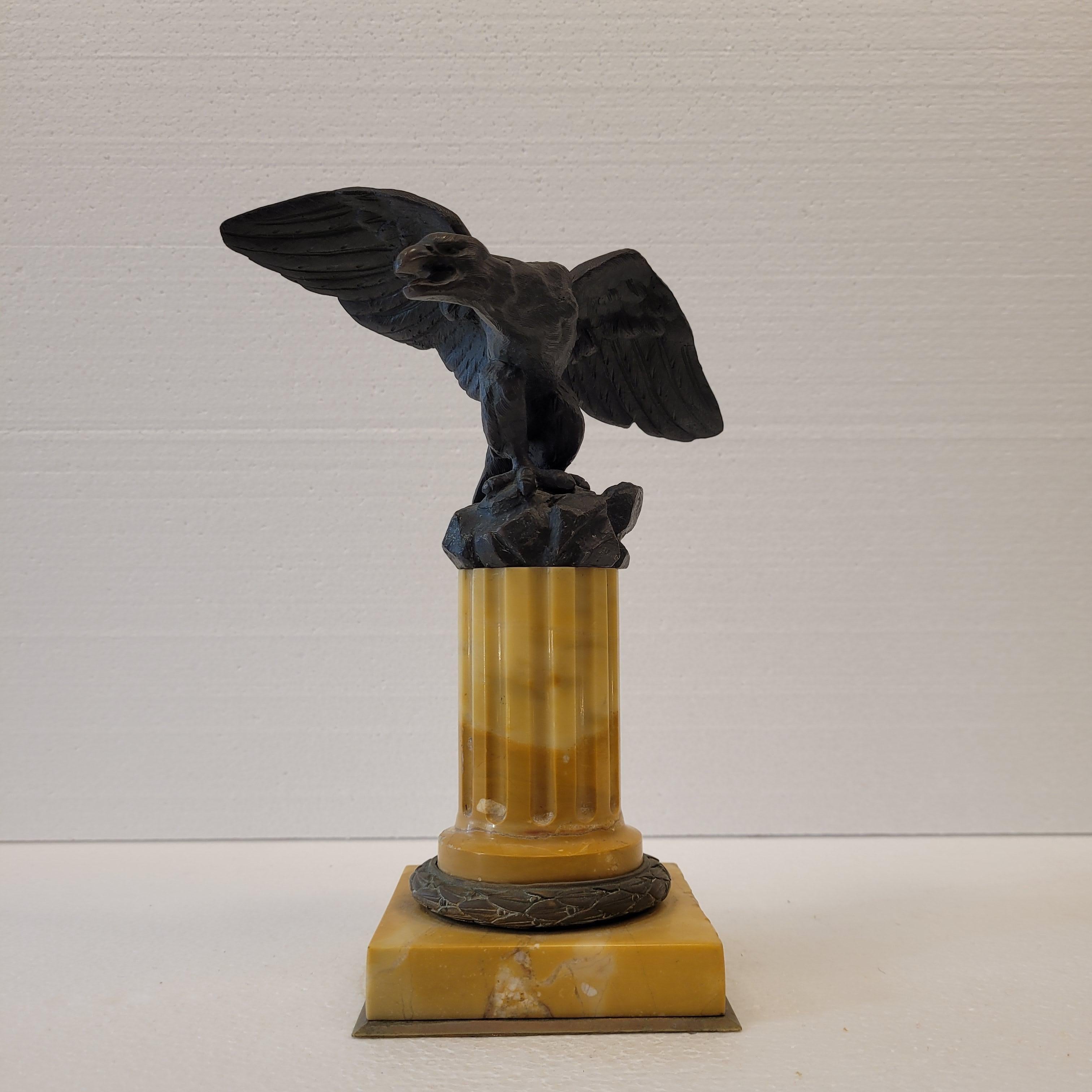 Exceptional and amazing bronze figure of an eagle, Napoleon III style and period. Seated on a pedestal in the shape of a fluted column of yellow Siena marble, the eagle is depicted just before taking flight, with its wings spread and on a rocky