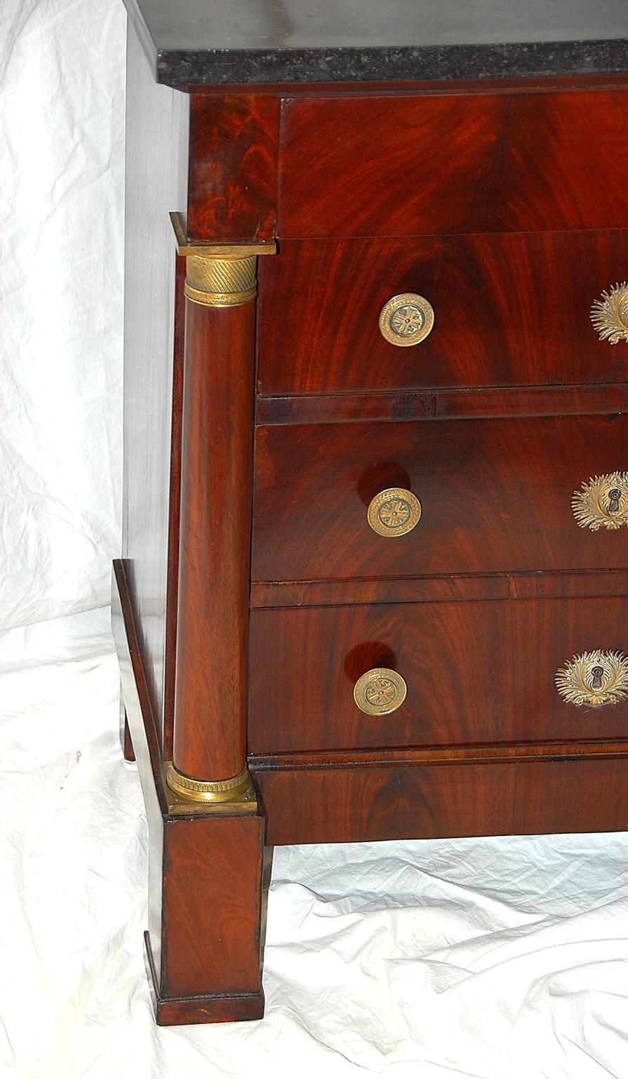 French Second Empire period mahogany chest of drawers with original removable black marble top. The flame grain mahogany is beautifully matched through the drawers. This small 32 inch chest has free standing carved columns with ormolu mounts and