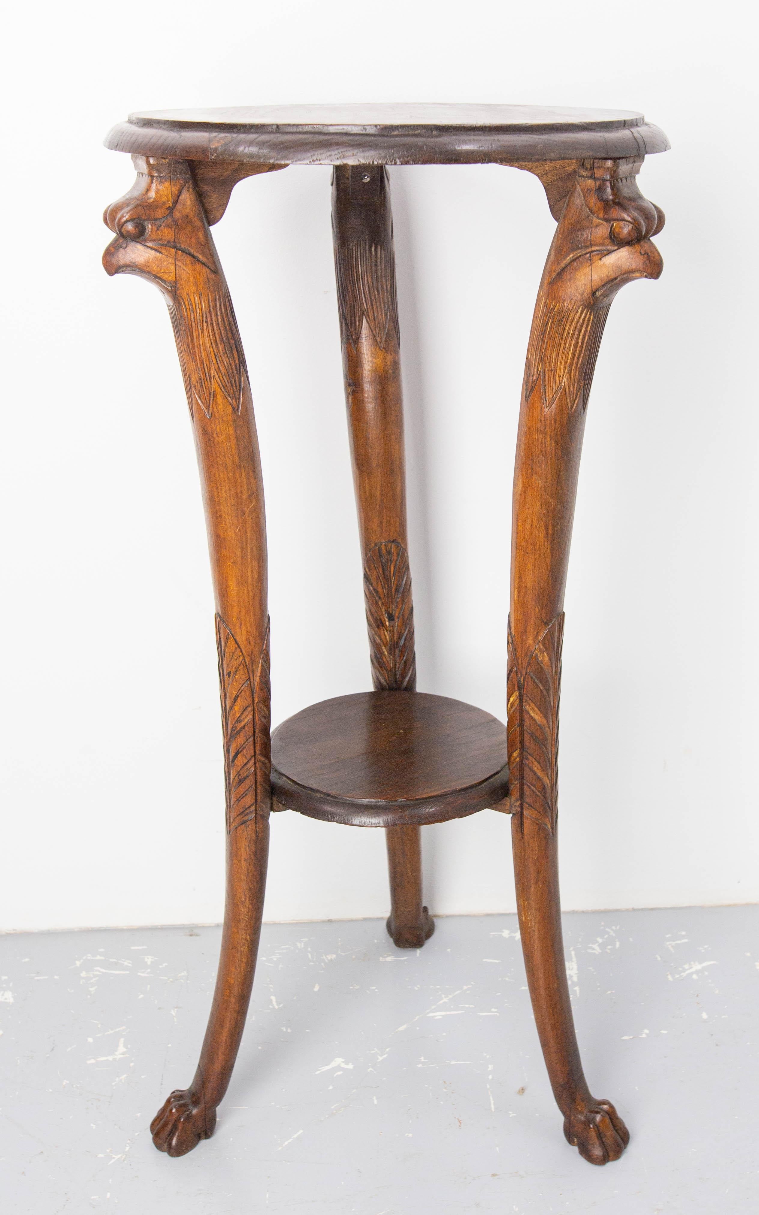 This plant holder or sellette was made in the middle oh the 19th century.
The legs of this harness make this table a unique piece of furniture: at the top, each leg begins with an eagle's head with a severe gaze, which is extended by a collar of