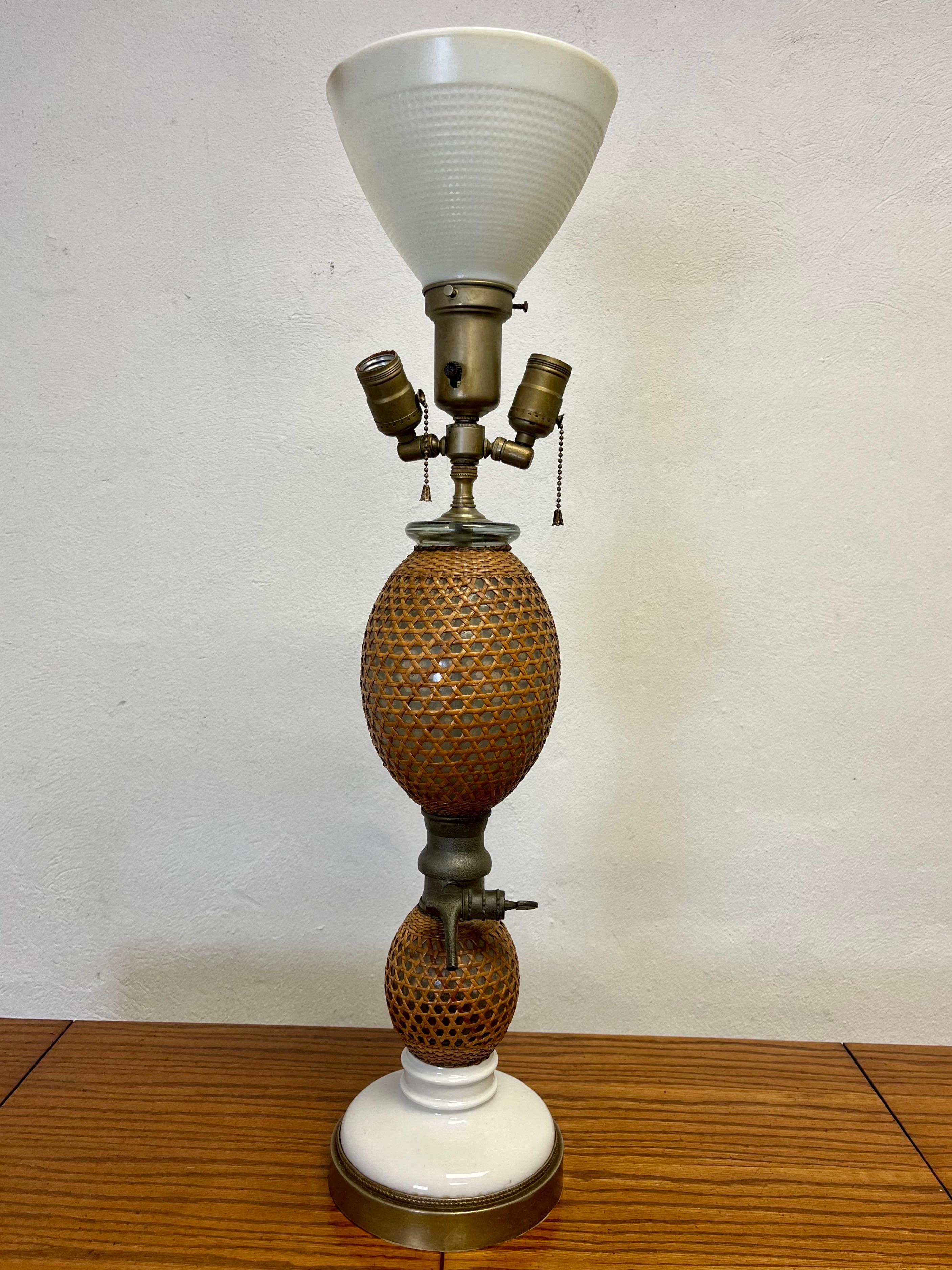 Antique seltzer bottle now table lamp with classic wicker wrapped double gourd form, zinc spouts signed Paris and porcelain bases in turned wood feet.