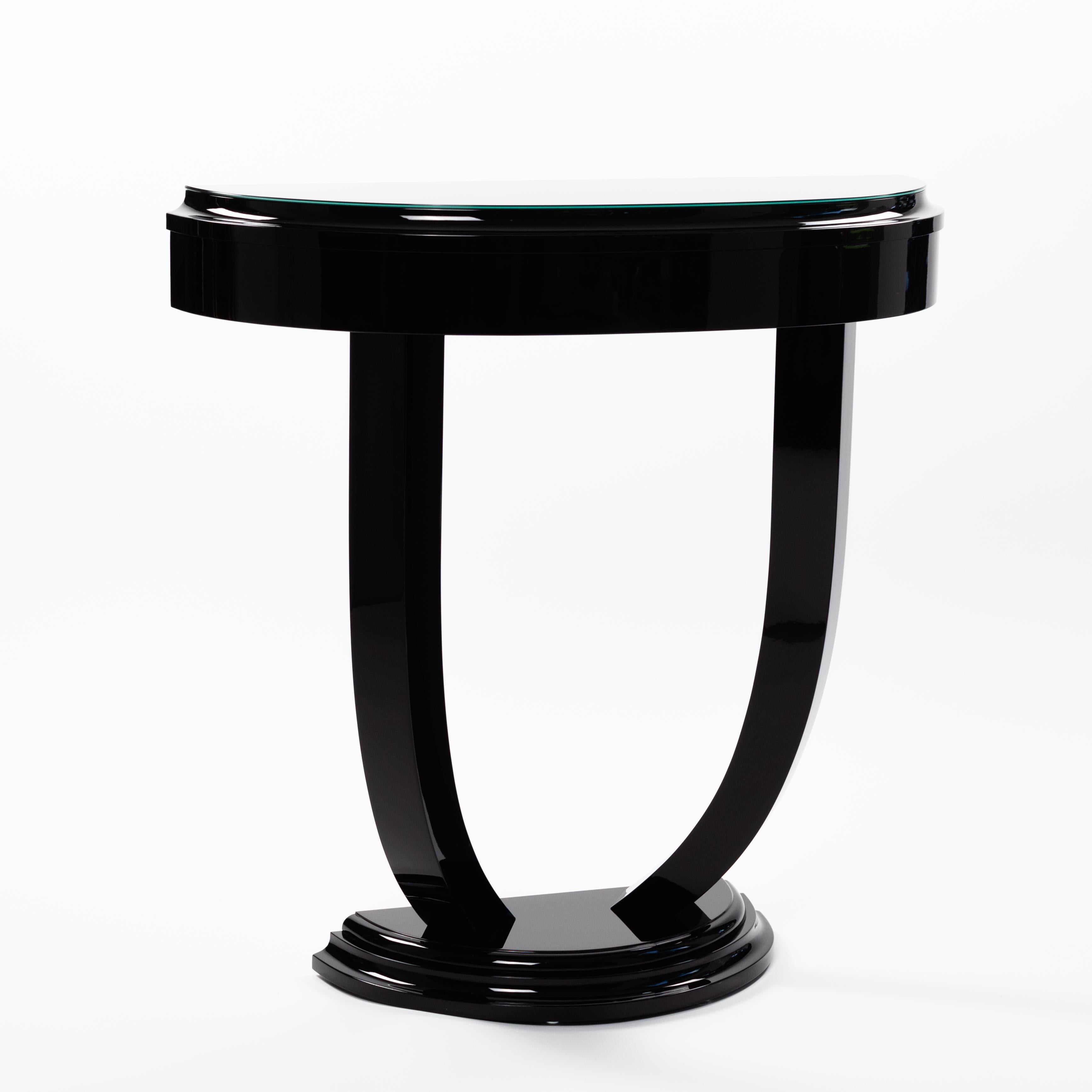 Semicircular Art Déco console black piano lacquer, black glass top plate

Elegant, light-footed object in the Art Déco style with a profile between the top and frame, profiled base. 
The black glass top was made to protect the cover plate and is