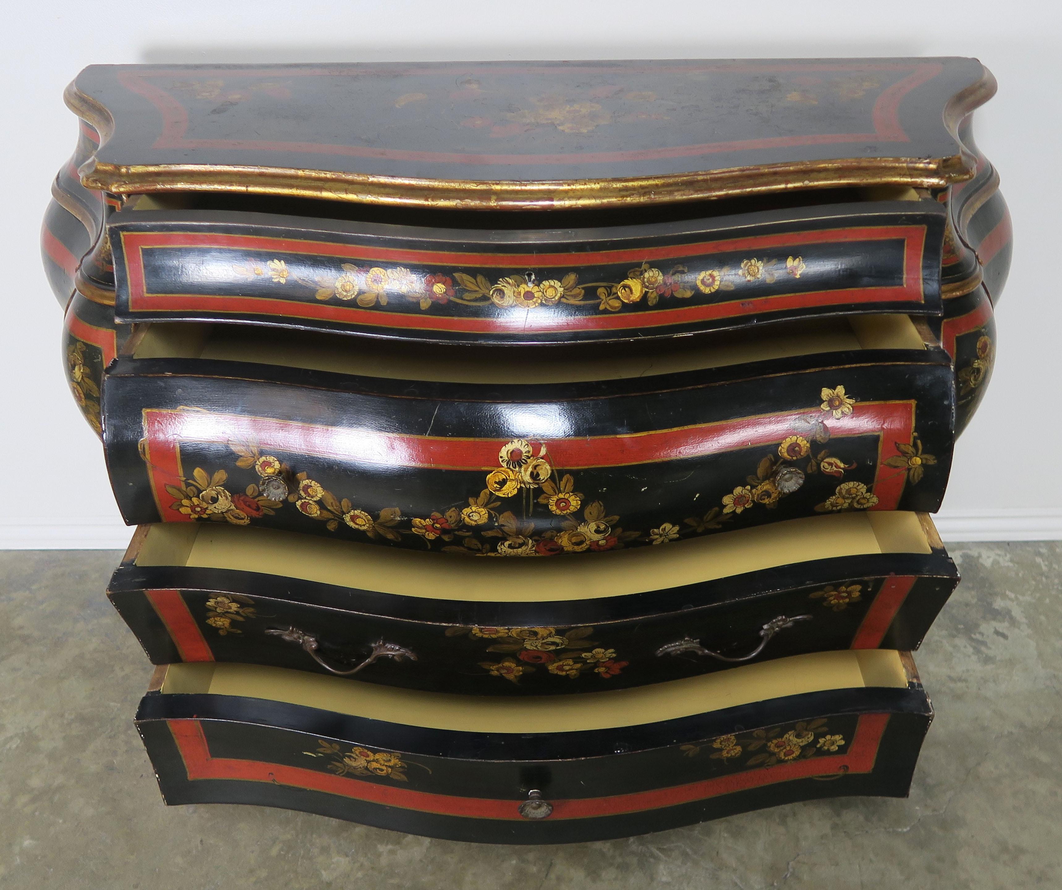 French chinoiserie painted and black lacquered Bombay chest of drawers. The piece is painted in black lacquer with red and gold accent details throughout. There are three large drawers and two smaller drawers on the top for ample storage. The chest