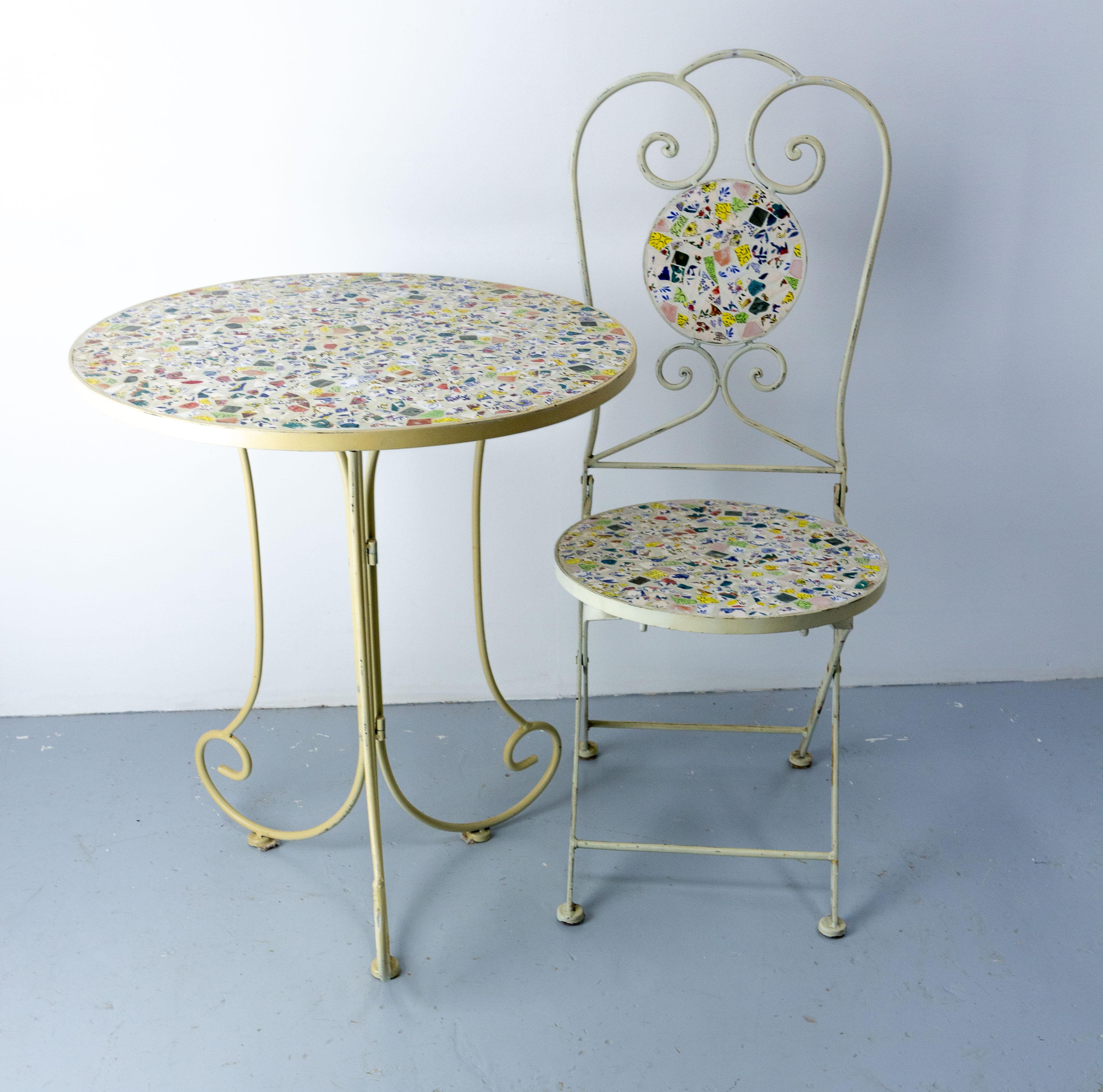 French folding iron chair and table, decorated with colored faience in concrete
Good condition with authenticate patina.
Each piece is fold-able.
Dimension: 
chair: D 19.68 in. W 15.35 in. H 38.19 in. Seat H 18.50 in. ( D 50, W 39, H 97, H seat