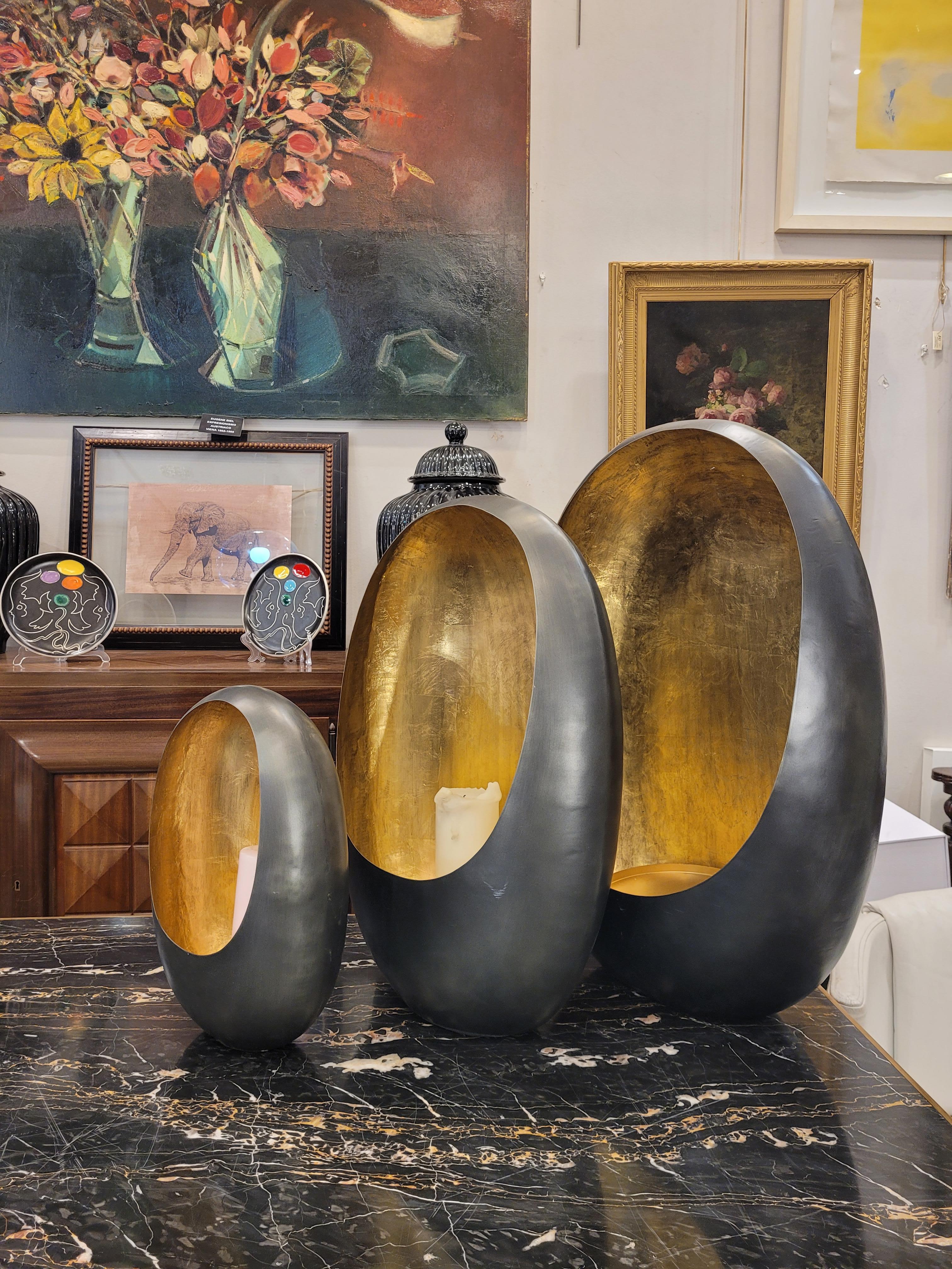 Extraordinary and gorgeous set of 3 lanterns or photophores, French candle holders, handmade, in golden brass on the inside and black on the outside.
With an oval profile, 3 pieces from largest to smallest, they are striking, original and very
