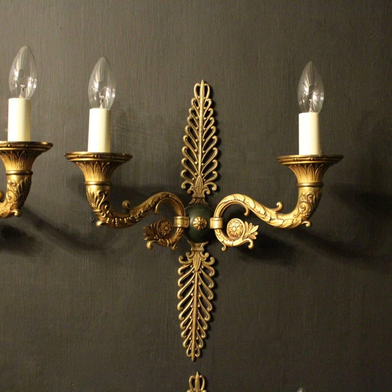 A lovely French set of four Empire gilded bronze and green enamelled twin arm antique wall lights, the tapering ornate scrolling arms with decorative etched candle sconces, issuing from a central ornate circular bulbous green enamelled backplate