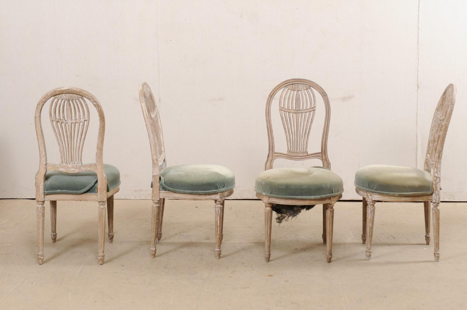 A French set of four carved-wood Jansen-style side chairs, with upholstered seats, from the mid 20th century. This set of vintage chairs from France each feature beautiful pierce-carved balloon backs, reminiscent of 18th century hot air balloons,
