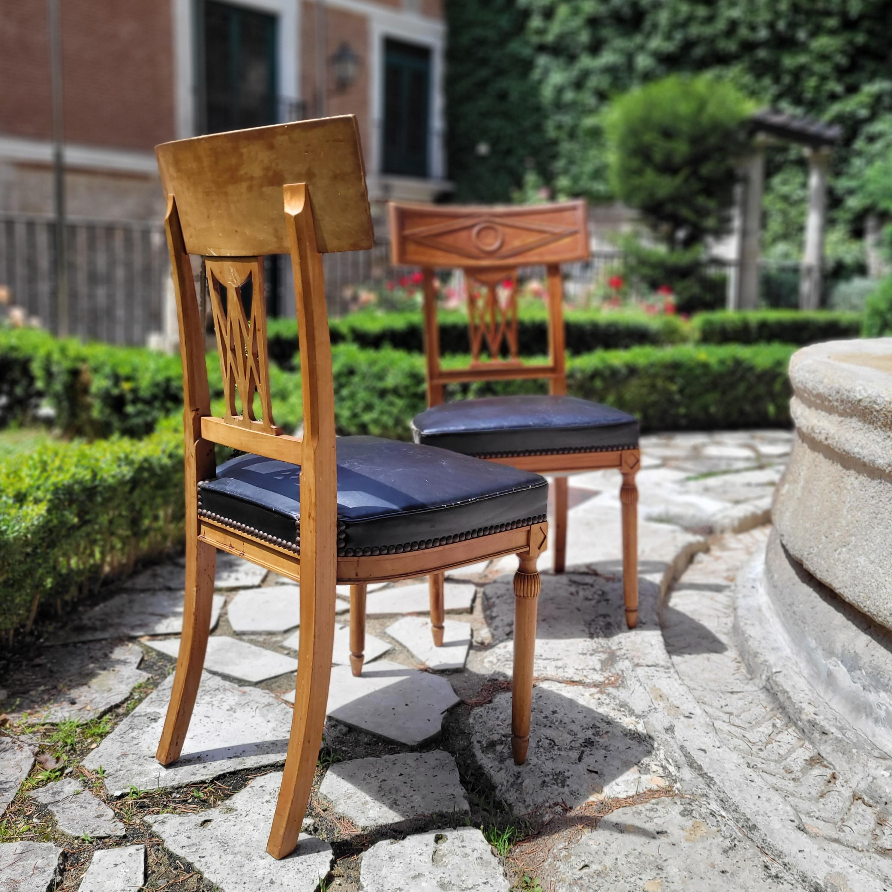 Outstanding  set of 6 chairs in the Directoire style, made during the first decade of the 20th century in France, in walnut wood and with the seat upholstered in black leather. Simple structure, in richly carved wood. The backrest shows an elegant
