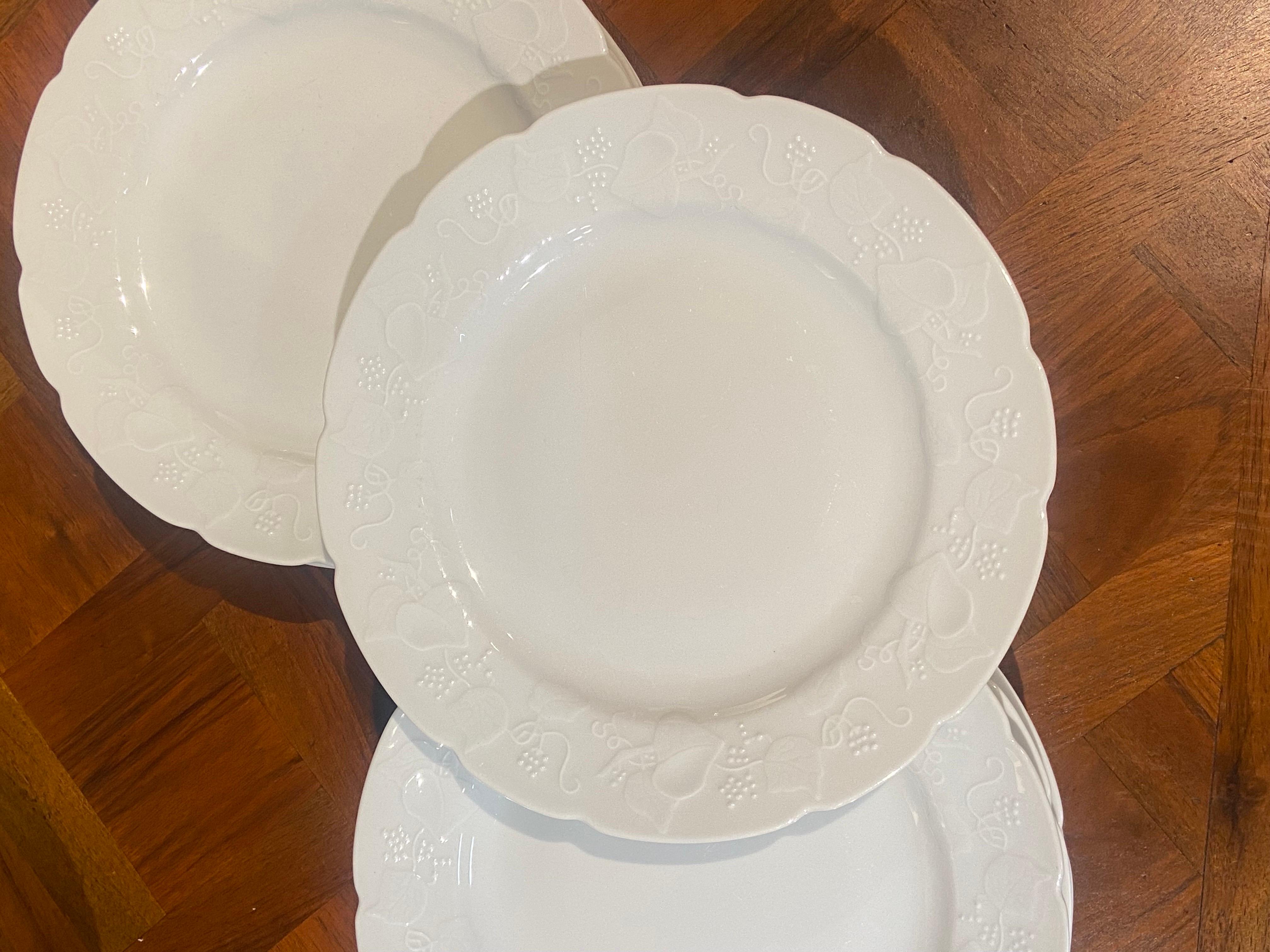 Ensemble de onze assiettes plates de Lierre Sauvage CNP en céramique blanc cassé avec de jolies décorations.
