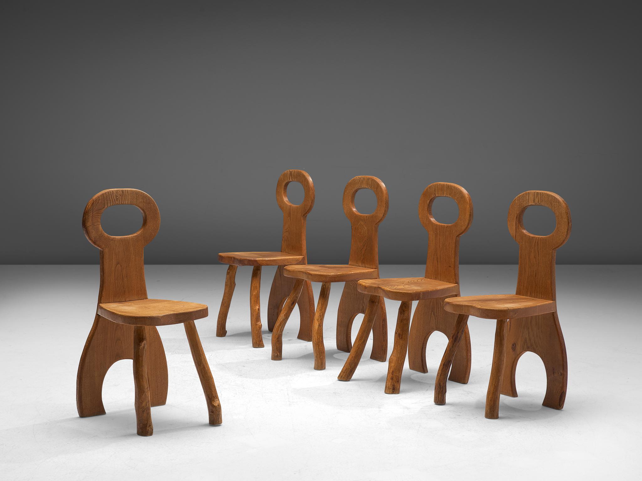 Set of five dining chairs, oak, France, 1960s.

Oak wooden chairs that has robust design with organic elements. The bulky seats are made of beautiful oak wood that developed a nice, rustic patina over the years. The design features a bulky and