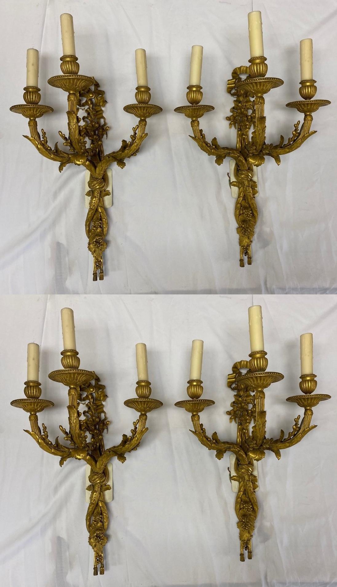 Exquisite 19 century French set of 4 ormolu two light sconces with handmade wax candle sleeves.
Late 19th century
Each with a ribbon and woven grapevine design supporting three acanthus-adorned candle lights, meticulous attention has given to