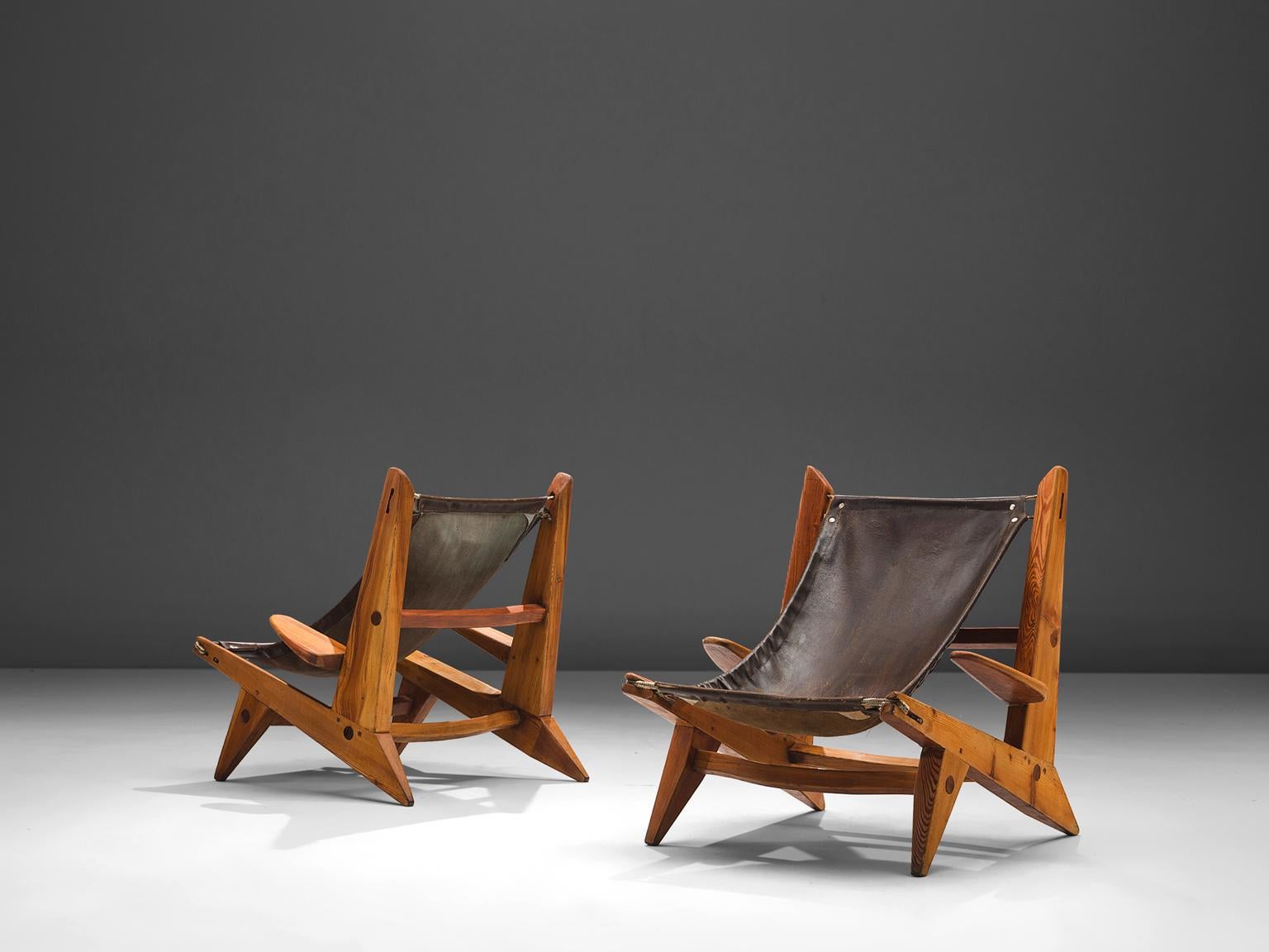Hunting easy chairs, leather, pine, France, 1950s.

This set of robust safari chairs features wonderful patinated leather on both seat and back. This patina creates a vibrant look. The chairs are sculptural and chunky and will fit perfect in a