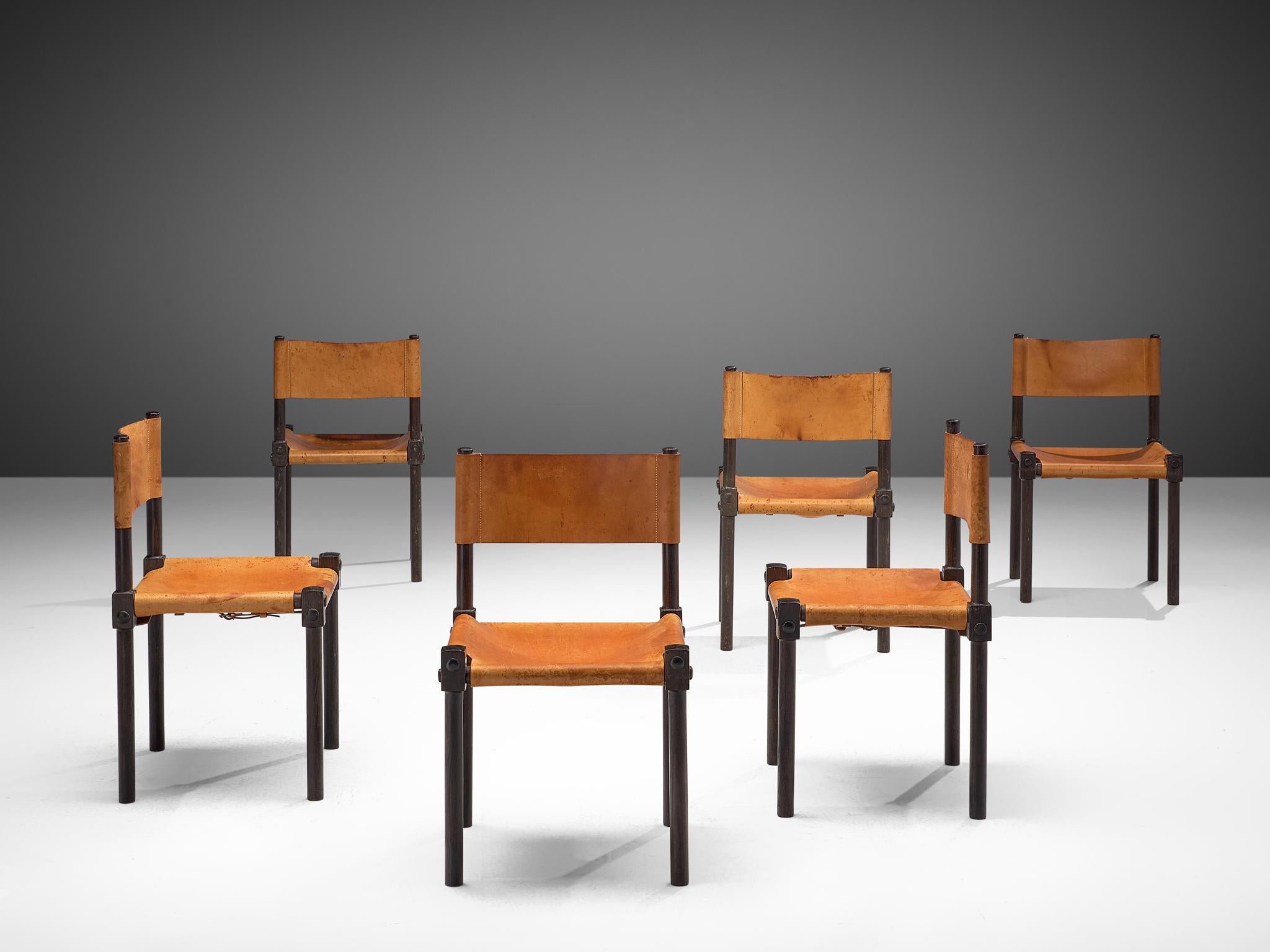 Set of 6 dining chairs, leather and wood, France, 1970s

This set of six sophisticated leather chairs features a strong structure. The wooden joints of the ebonized frame are not concealed but emphasizes the constructions. The chairs are covered