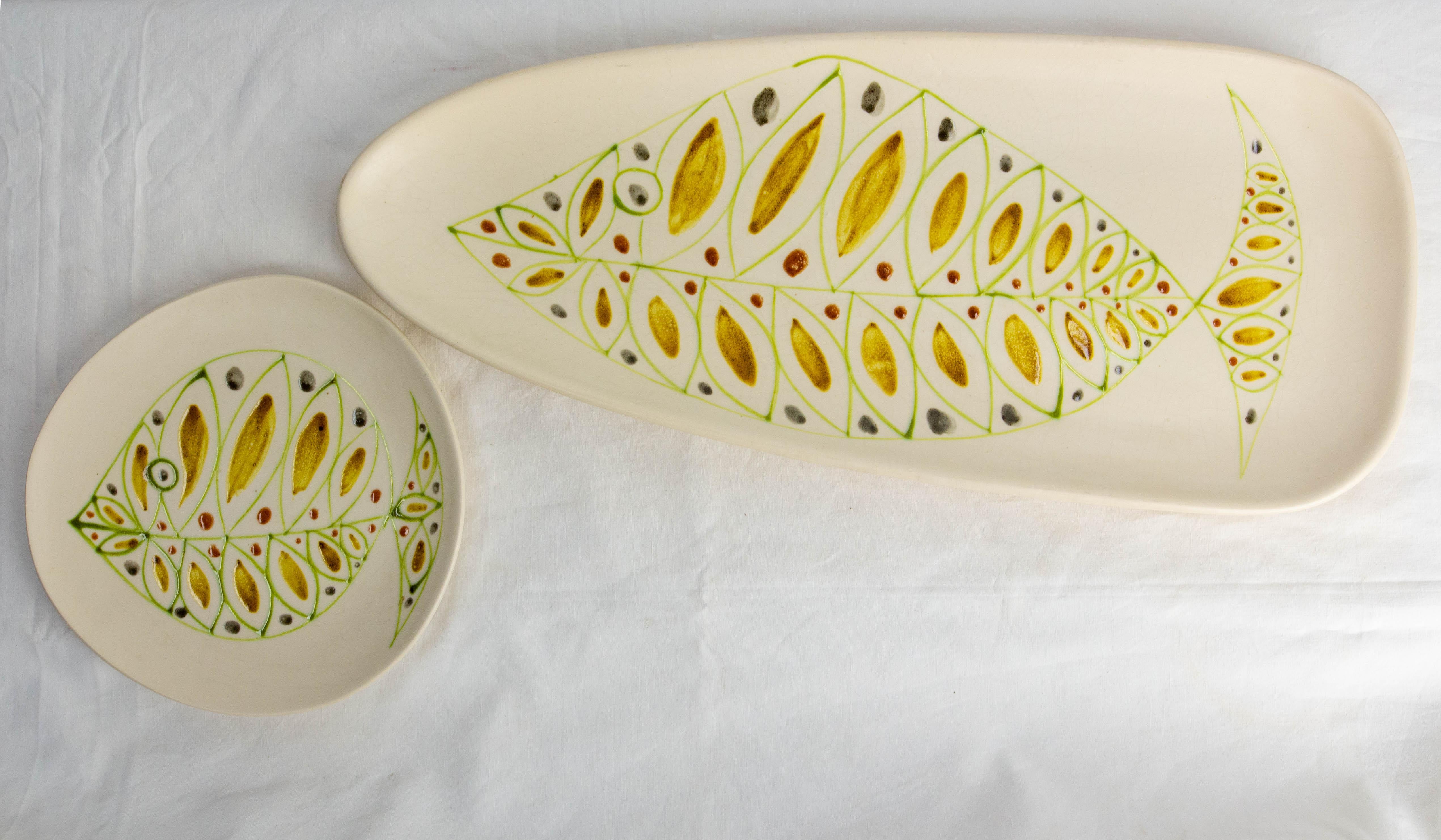 Dishes set: long fish dish or centerpiece and plate, France Midcentury.
The two pieces were made in Niderviller Manufactury in the East of France.
The Niderviller manufactory is still active today.
On each plate a fish was
