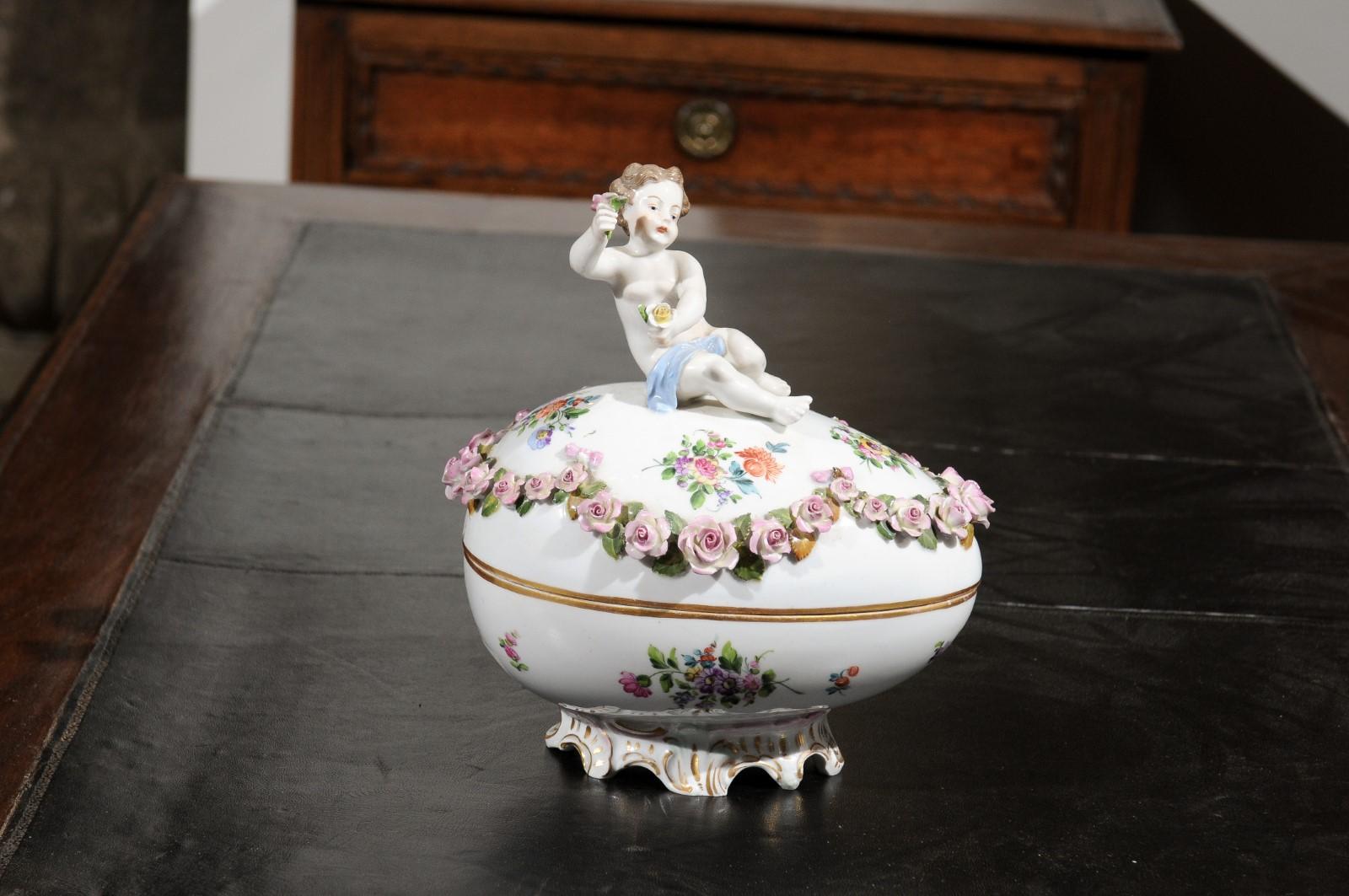 Ein französisches Porzellan-Ei der Manufaktur Sèvres aus dem 19. Jahrhundert, mit Putten- und Blumendekor von Hand bemalt. Dieses im 19. Jahrhundert in Frankreich entstandene, exquisite Deko-Ei zeigt auf seinem ovalen Deckel einen Putto, der in