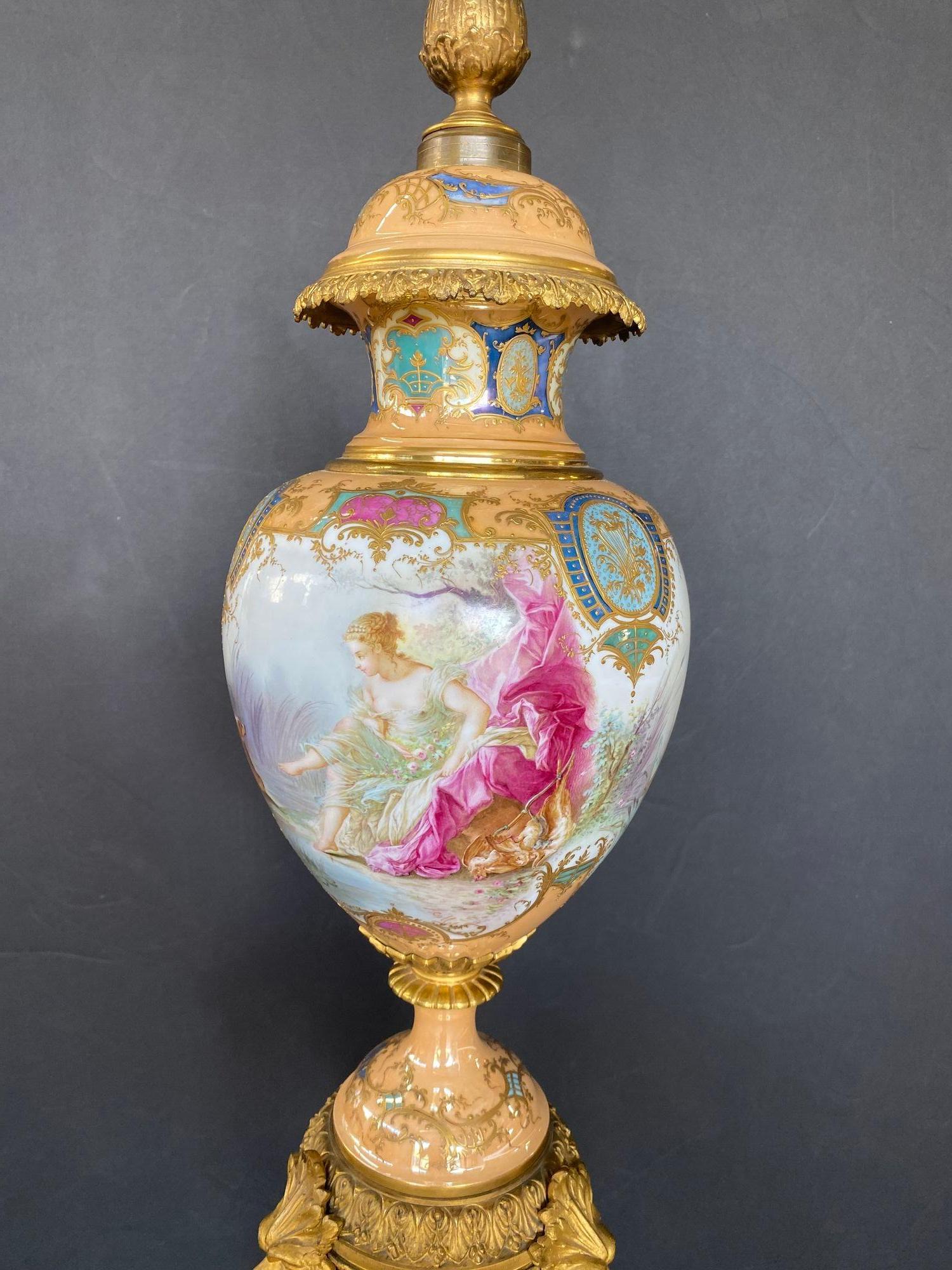 Urna francese di Sèvres in porcellana montata in bronzo dorato. Il corpo oviforme è dipinto a mano con una scena continua di un paesaggio con una ninfa e un cane su un lato e un cherubino in una barca a forma di conchiglia sull'altro; montato su un