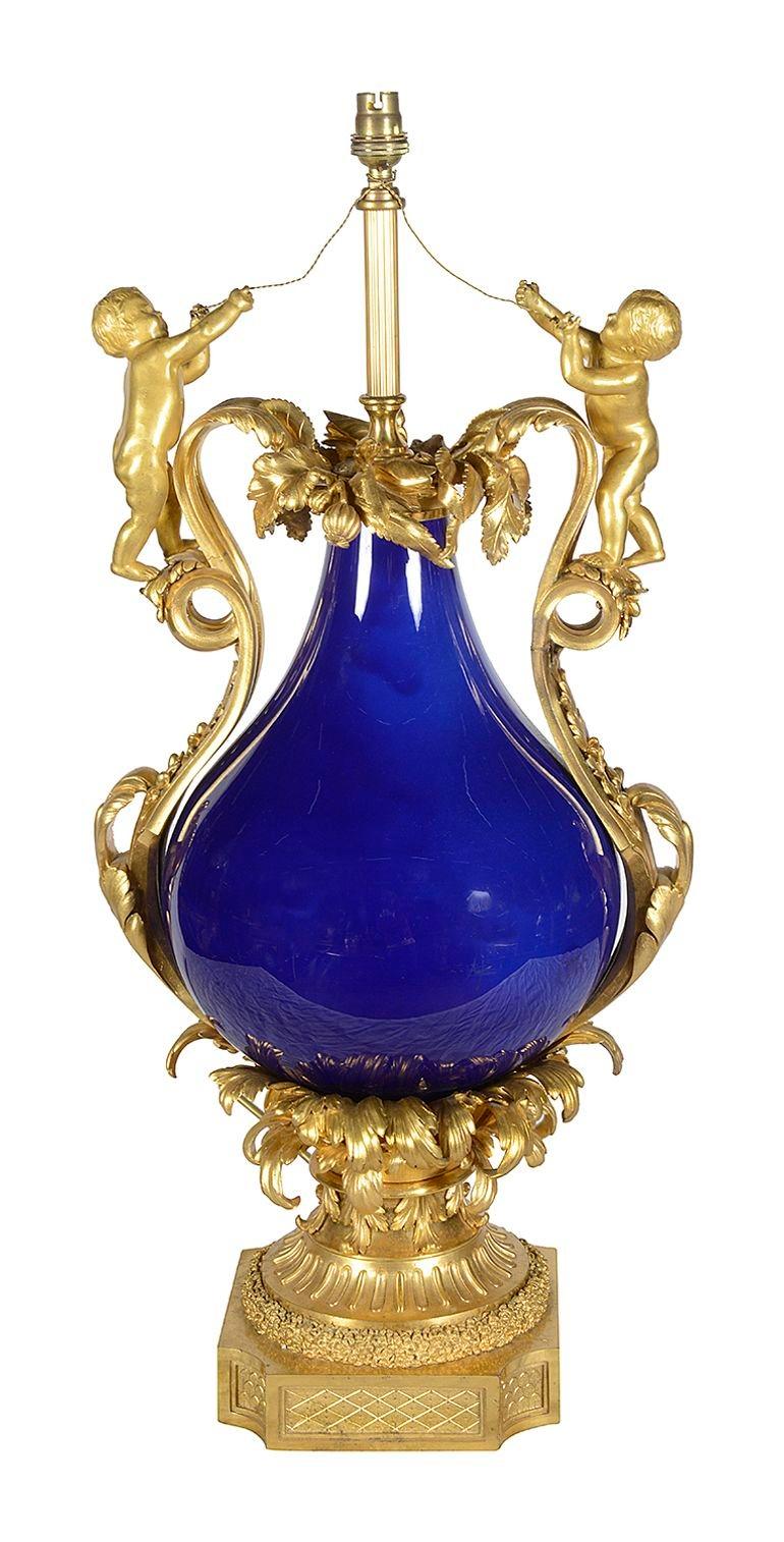 Impressionnant vase / lampe en porcelaine bleu cobalt et bronze doré de style Louis XVI de la fin du XIXe siècle.
Le vase en porcelaine bleu cobalt repose sur des feuilles de palmier et une base en plinthe.

Lot 77 DYKKE