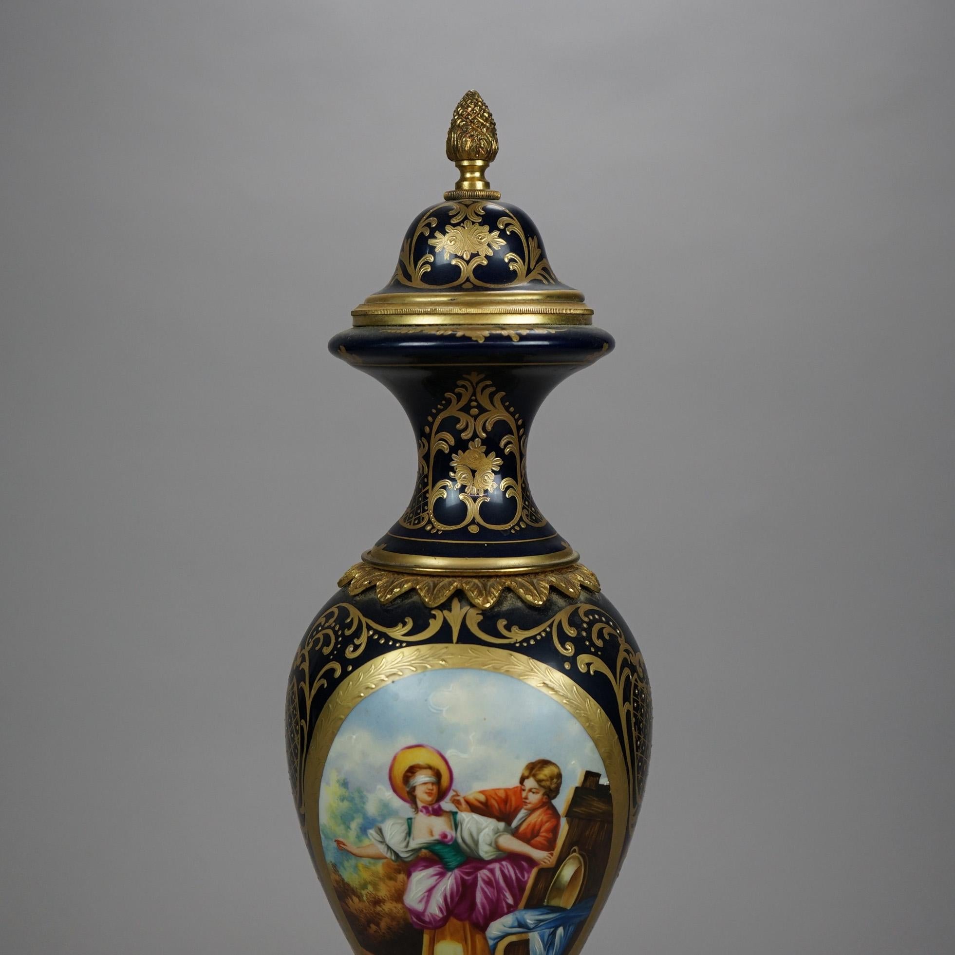 A French Sevres portrait vase offers porcelain construction in urn form with reserve having courting scene on cobalt blue ground with gilt highlights throughout, maker mark on base as photographed, 20th century

Measures- 19.25'' H x 5.5'' W x