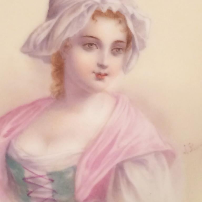 French Sevres portrait plate of a beautiful lady with a white hat and a pink scarf. The borders of this Sevres plate are very unusual as they have elaborate raised gilding including three raised gold butterflies in between three contrasting silver