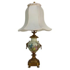 Lampe en porcelaine peinte et signée par l'artiste, Sèvres, poignées en forme de tête de lion