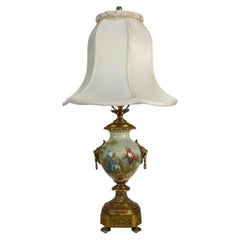 Lampe en porcelaine peinte et signée par l'artiste, Sèvres, poignées en forme de tête de lion