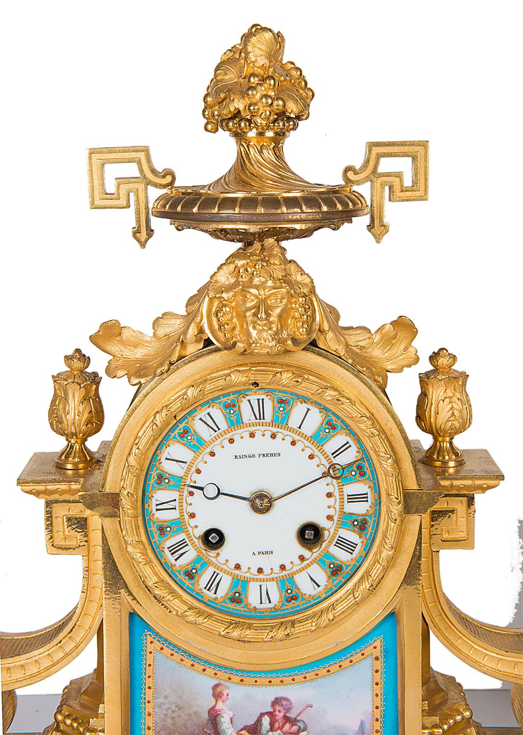 A good quality 19th century French gilded ormolu and Sevres style porcelain clock garniture. Having cherubs playing on either of the two branch candelabra. The clock with a two handled urn to the top, porcelain faced eight day chiming clock,