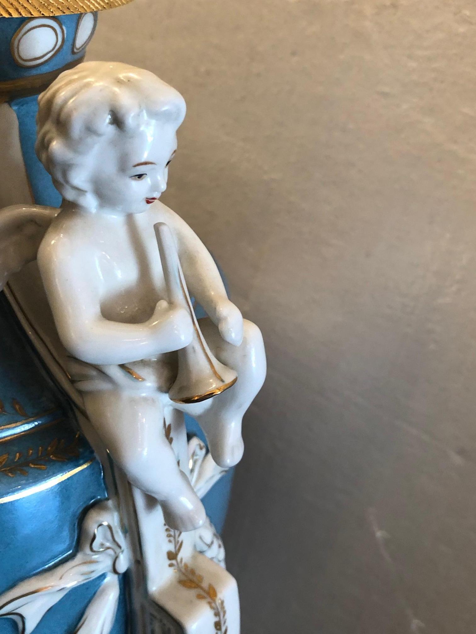 French sevres style covered porcelain urns, lids having pineapple finials, figural reserves, seated winged cherub handles.