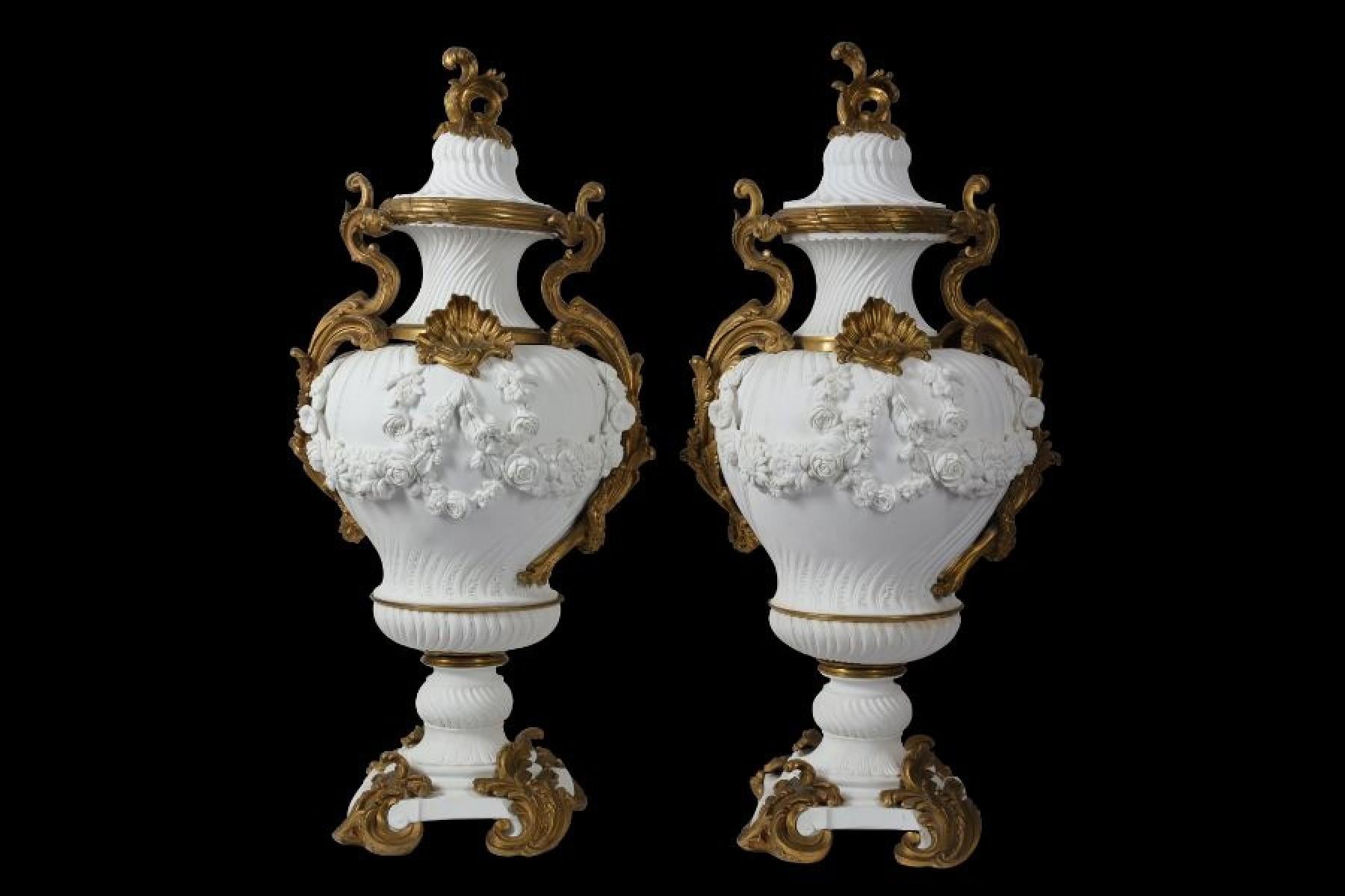 A pair of large impressive 19th century French gilt bronze mounted Sèvres style bisque porcelain vase and lids in the Louis XV style, with spiraling fluting throughout on square plinth bases.

They are ovoid in form and mounted with gilt bronze