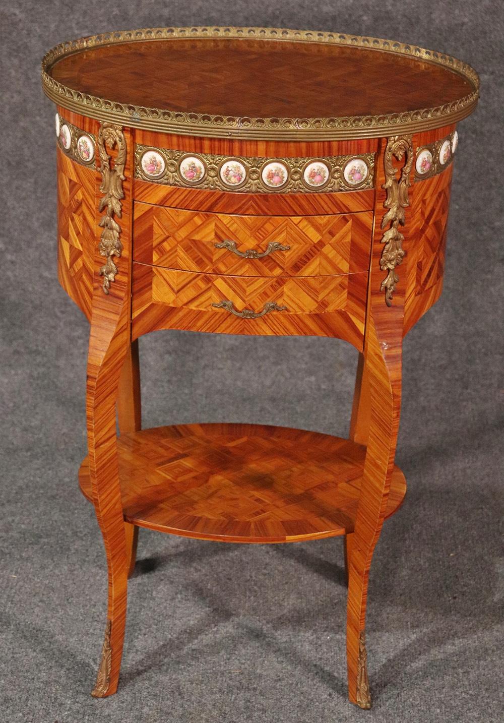 This satinwood French-made nightstand or end table features hand painted Sevres style porcelains surrounded by bronze ormolu and some stunning marquetry workmanship, circa 1950.