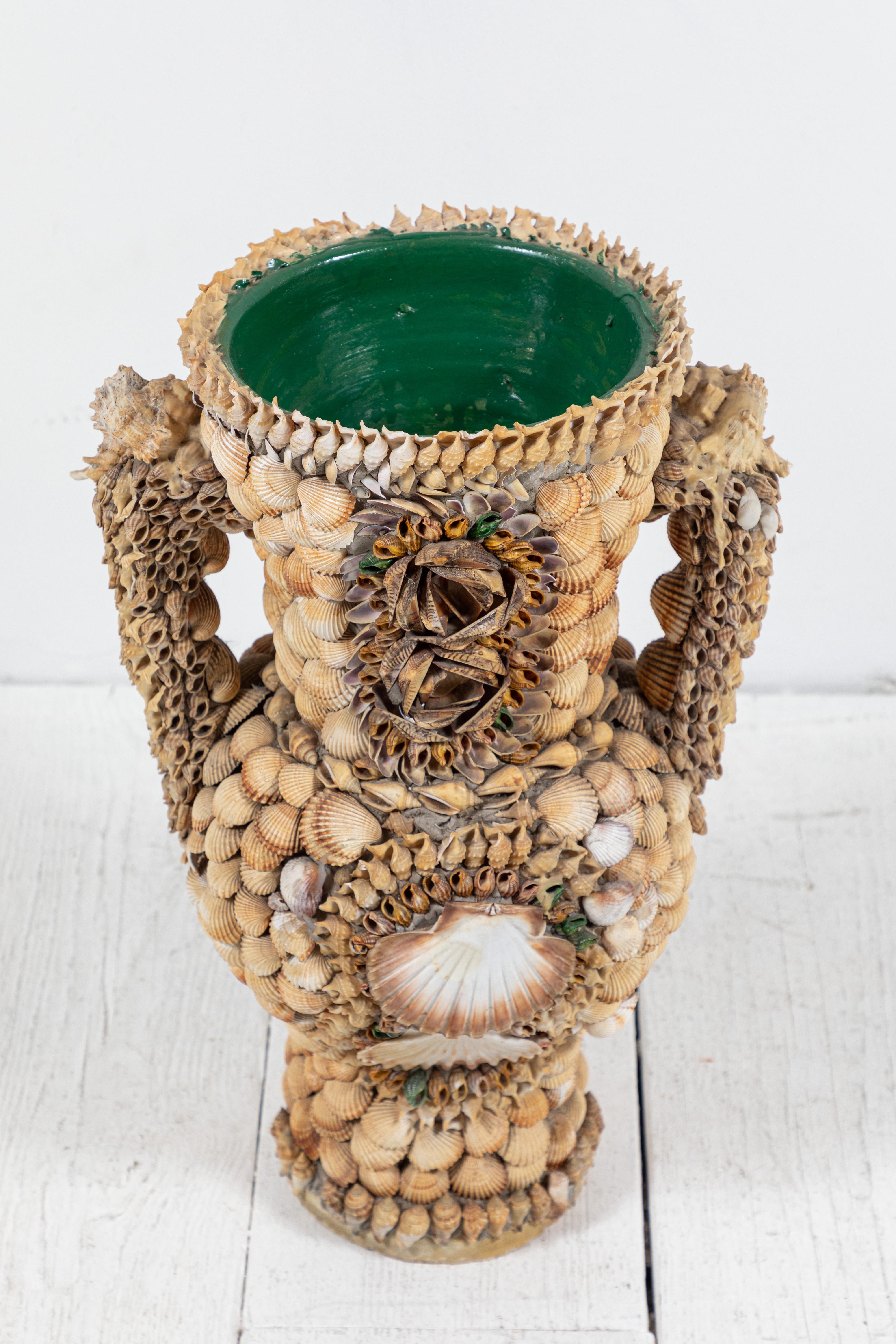 Fun and whimsical French urn adorned with an assortment of Shells. Interior glazed green.