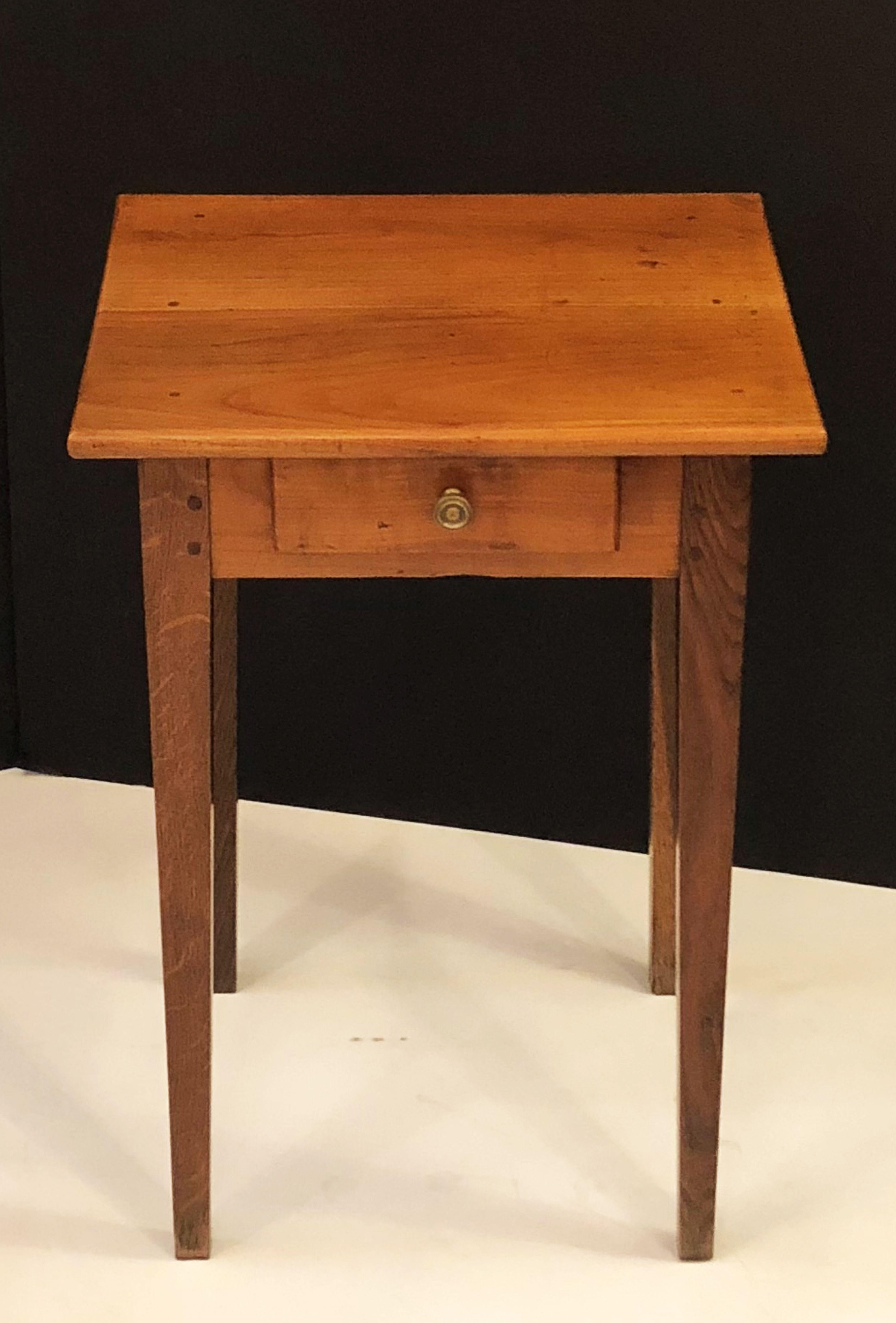 A fine French side table or writing table of cherry and oak, featuring a rectangular top over a frieze with drawer and brass knob pull, resting on tapered legs.

Dimensions: H 28 1/2 inches x W 20 inches x D 16 inches

Makes a great bedside