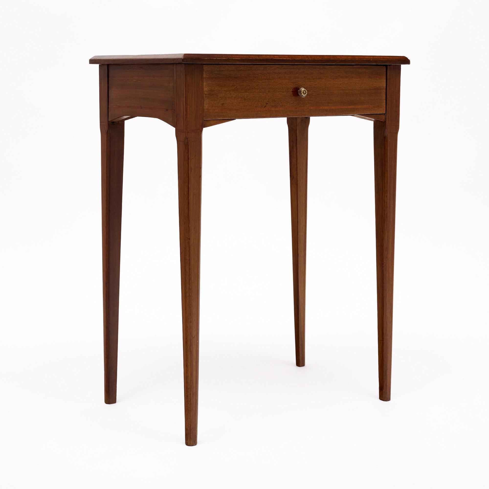 Table d'appoint française en bois massif. Cette pièce présente une belle incrustation de bois sur le dessus et un seul tiroir à queue d'aronde. Les quatre pieds fuselés ajoutent de l'élégance. Elle a été finie avec un vernis français lustré. Cette