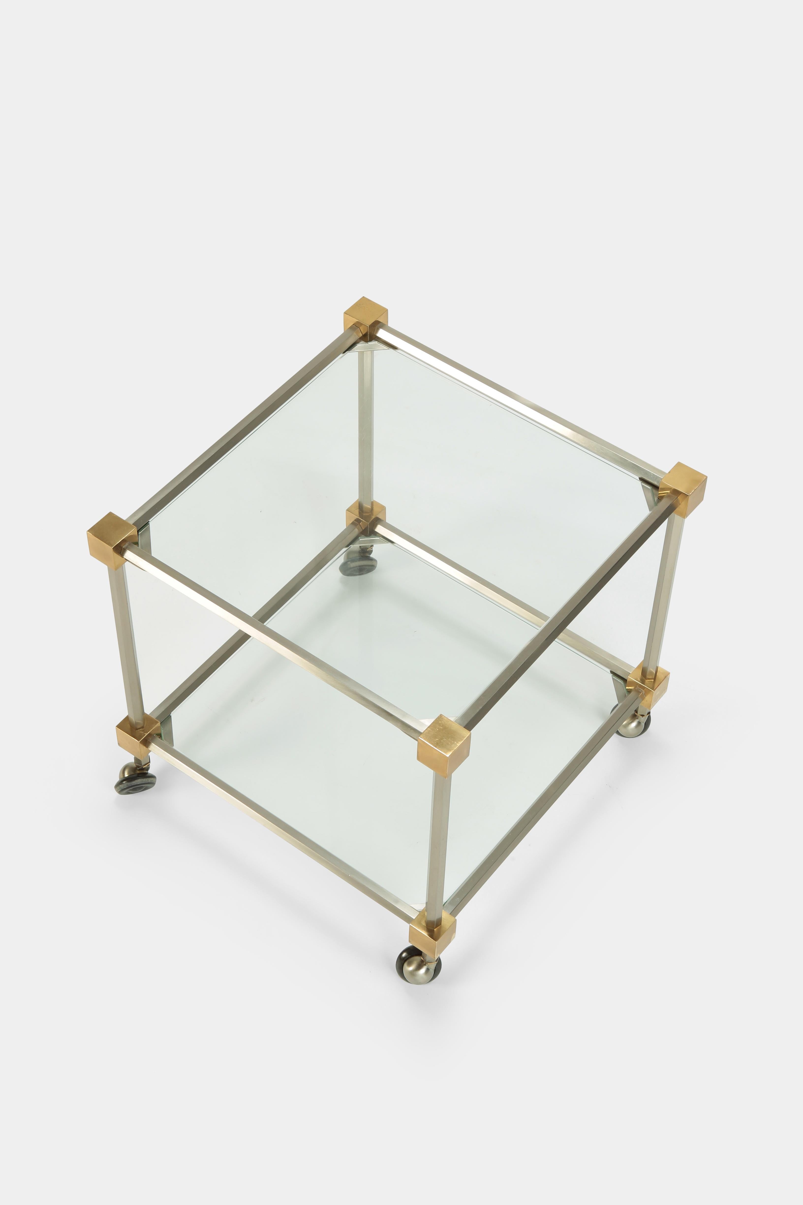 Maison Jansen side table manufactured by Maison Jansen in the 1970s in France. The frame is made of chrome steel with corner partes made of solid brass. Stands on wheels.