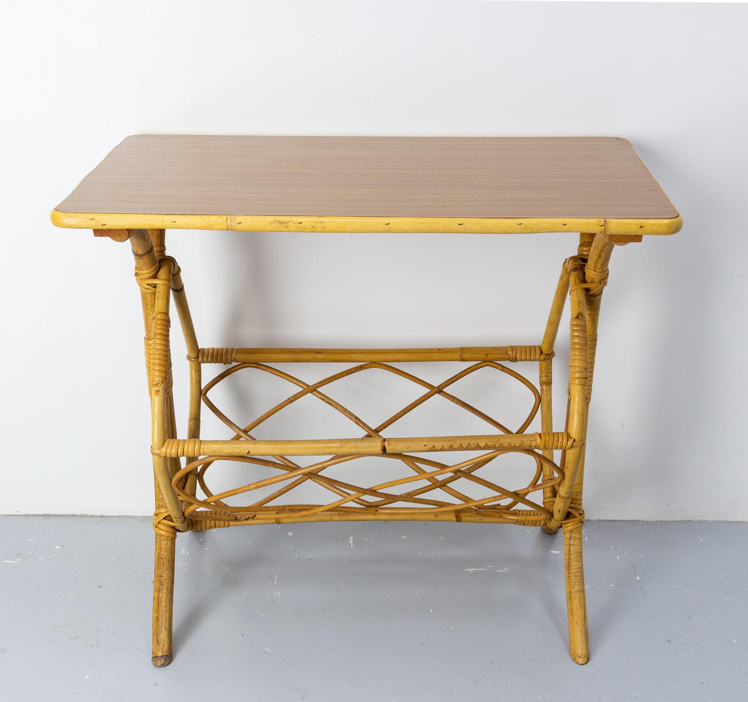 Rattan side table, laminated top wood imitation 
French, circa 1970
Very good condition

Shipping: 42 x 71.5 x 61 cm 4.4 kg.