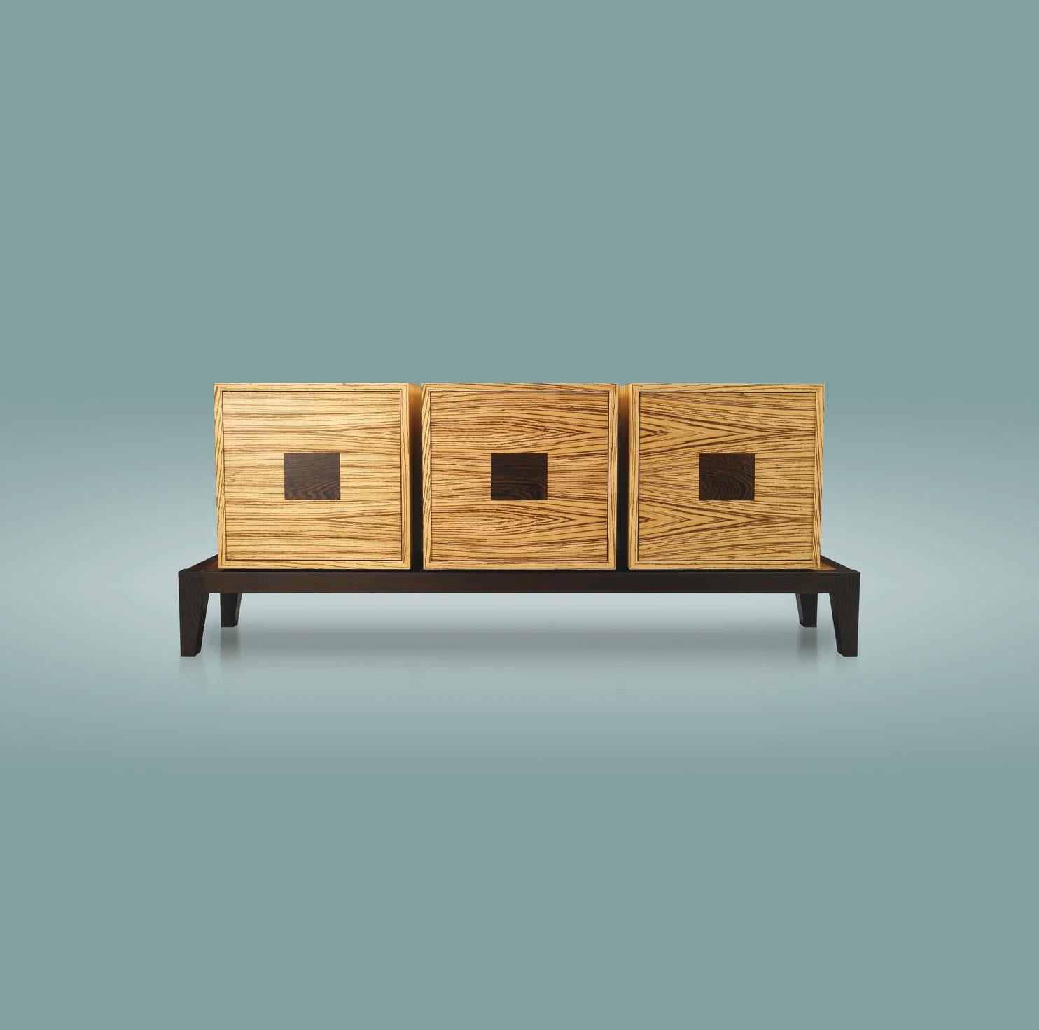 This box sideboard combines the breaking strength of its three boxes and the delicacy of its Japanese-style base. The dual colors of zebrano and wenge reinforce this beautiful marriage of formal oppositions. A stripped-down and modern composition