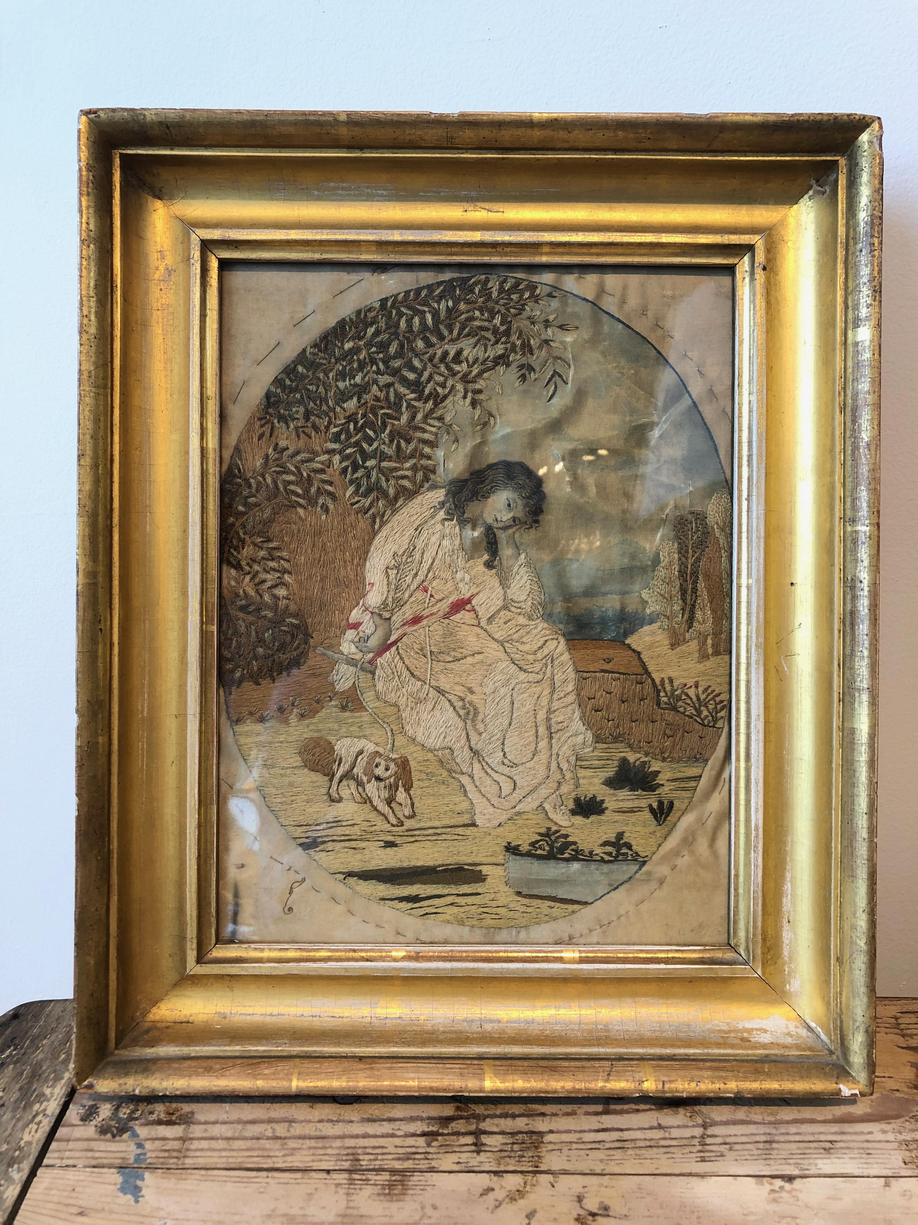 French silk needlepoint of girl and dog in gilded frame.