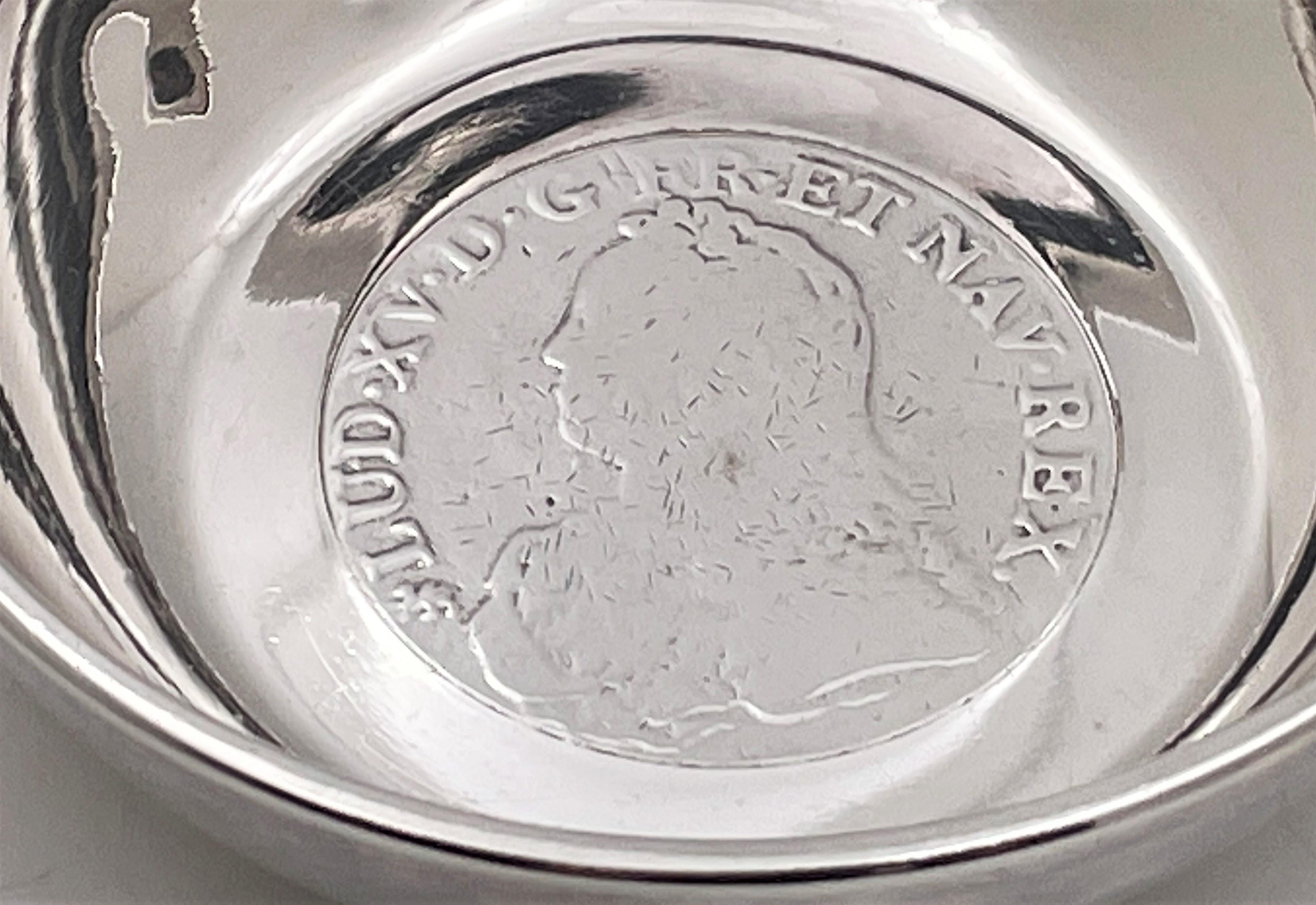French silver tastevin or wine taster, possibly from the Louis XV era (1732), showcasing a profile view of Louis XV in a coin-like manner at the bottom of the small bowl. On the reverse, there is another motif with the Latin inscription: Benedictum