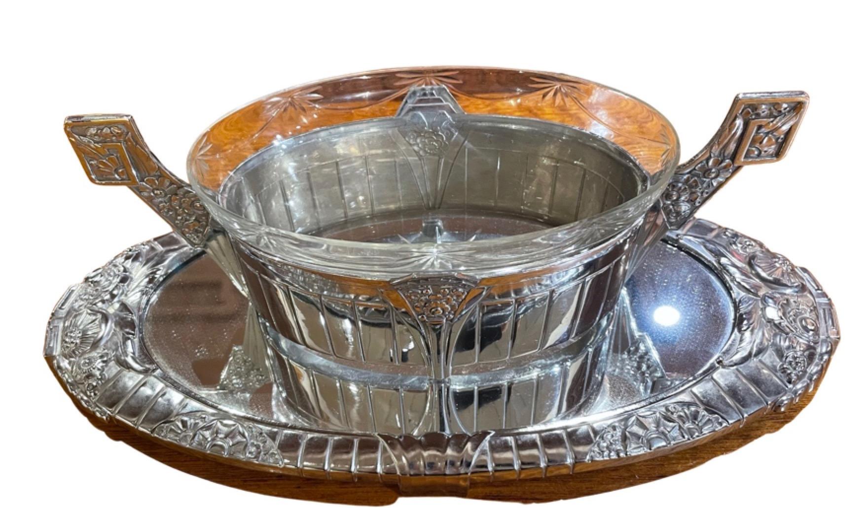 A silver and mirrored centerpiece, elaborate and ornamental from the late 1920s. The great metalwork was created by Orfevrerie Dilecta, a French company that specialized in these pieces (often called Jardinieres). They began production in the Art