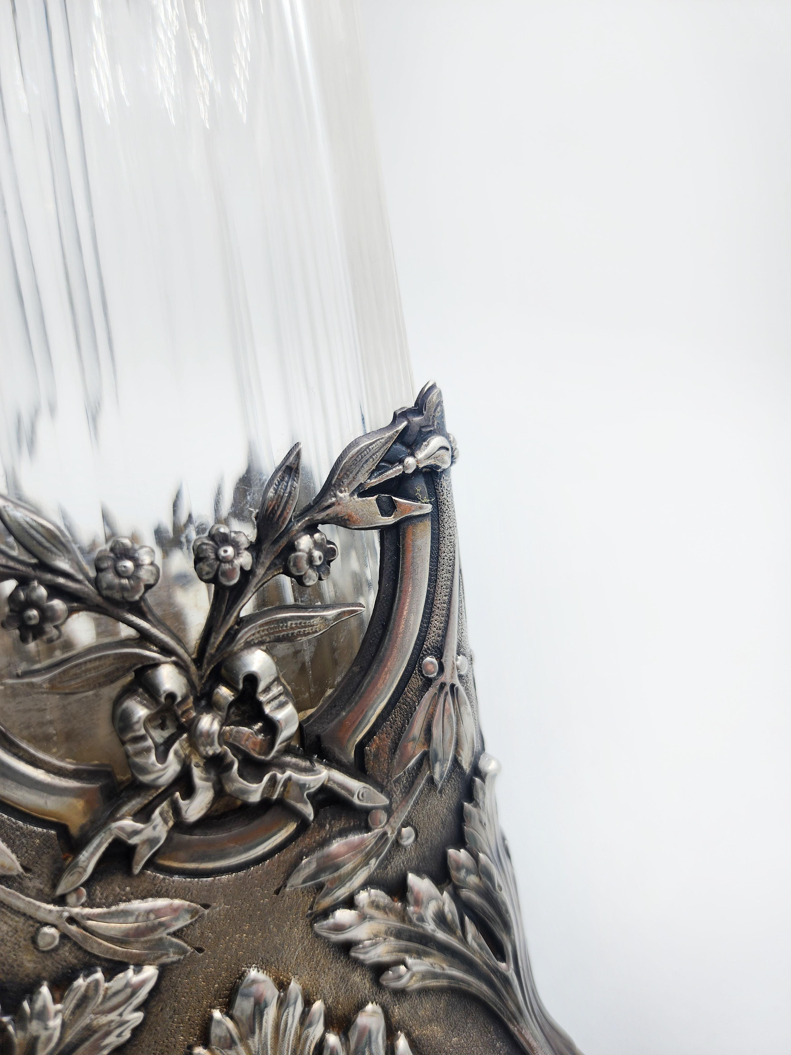 Vaso francese in argento Art Nouveau
Bellissimo vaso francese in argento e vetro con un'apertura svasata nella parte superiore. Il vaso poggia su una base d'argento decorata con disegni intricati, tra cui motivi floreali. La combinazione di vetro e