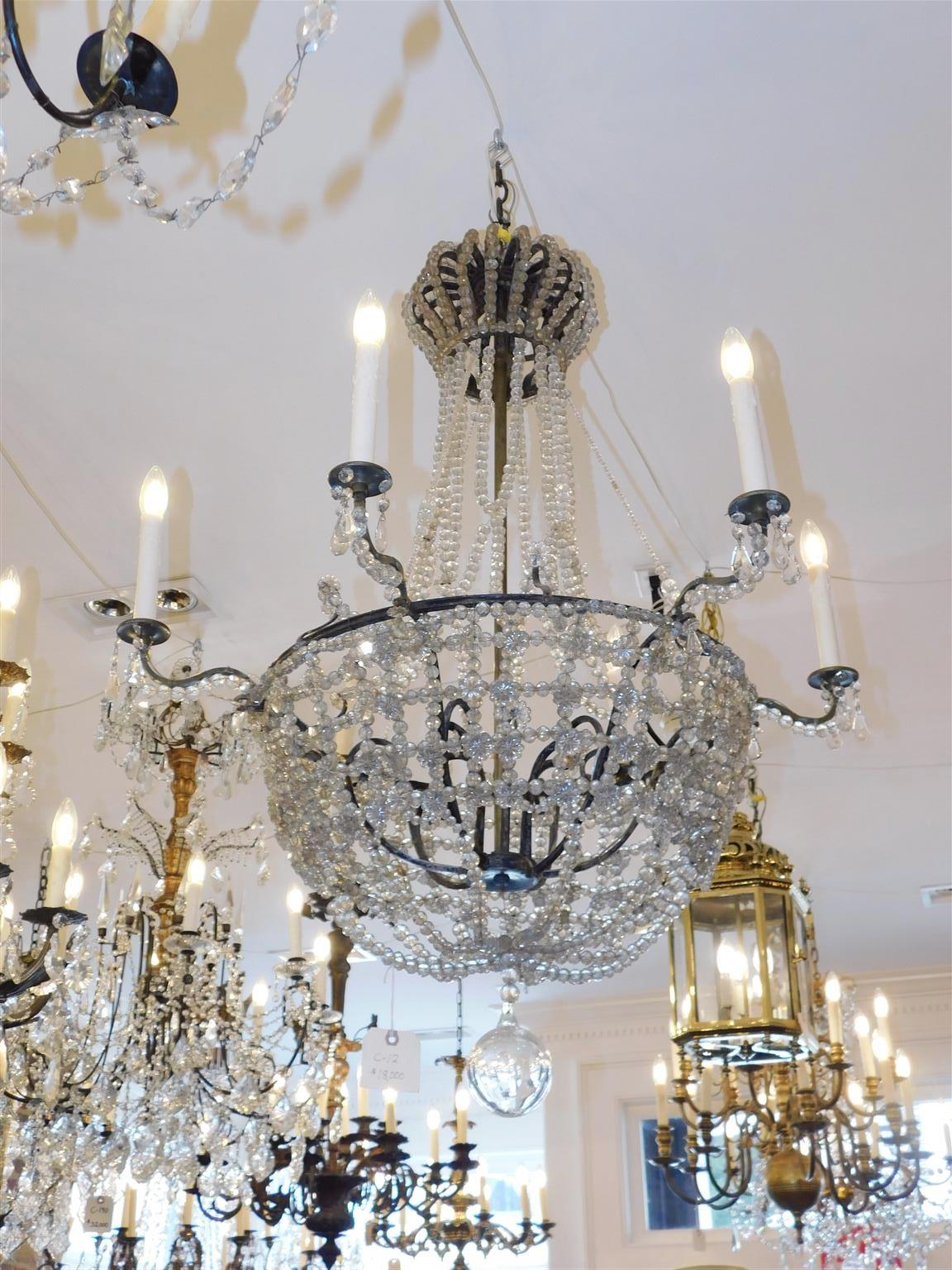 Lampadario francese in cristallo argentato e bronzo con sei bracci a voluta, baldacchino a corona e terminale a sfera sfaccettato, inizio XIX secolo.
Il lampadario era originariamente alimentato da candele ed è stato elettrificato.
