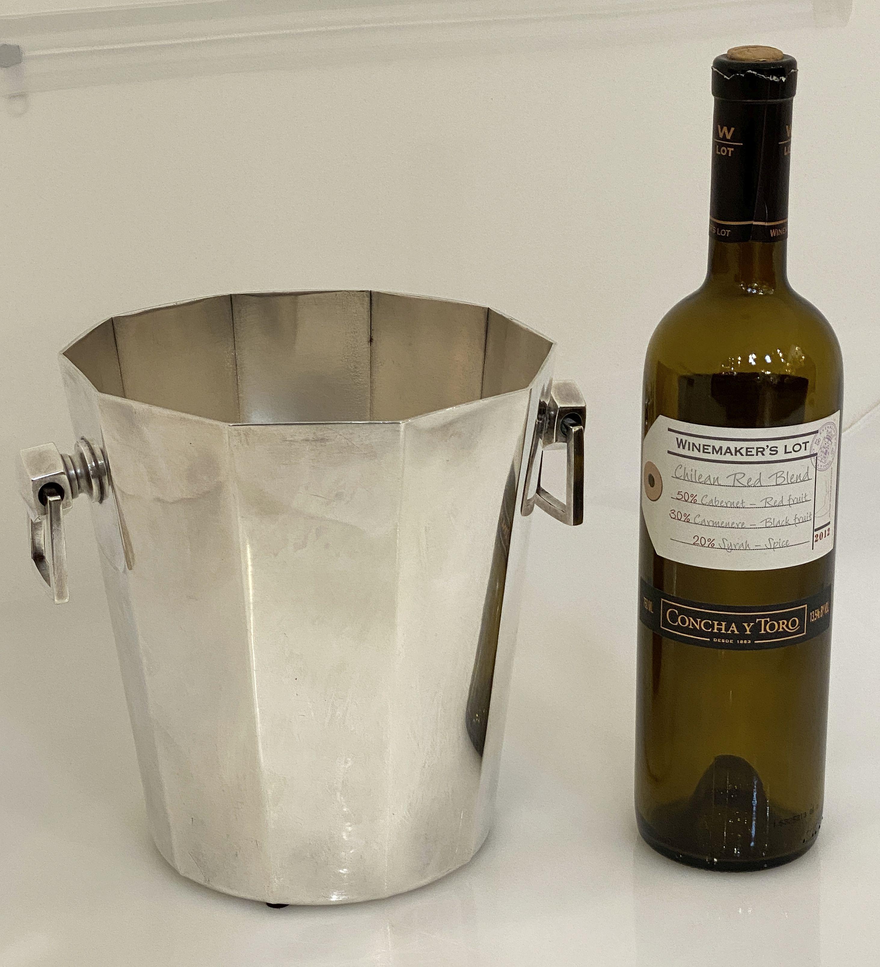 A faceted French champagne bucket or wine cooler of fine plate silver in the Modernist style, featuring an elegantly ten-sided tapering body with two opposing pendant handles.

Impressed hallmarks on base.

Dimensions are

Height 8 inches x Diameter