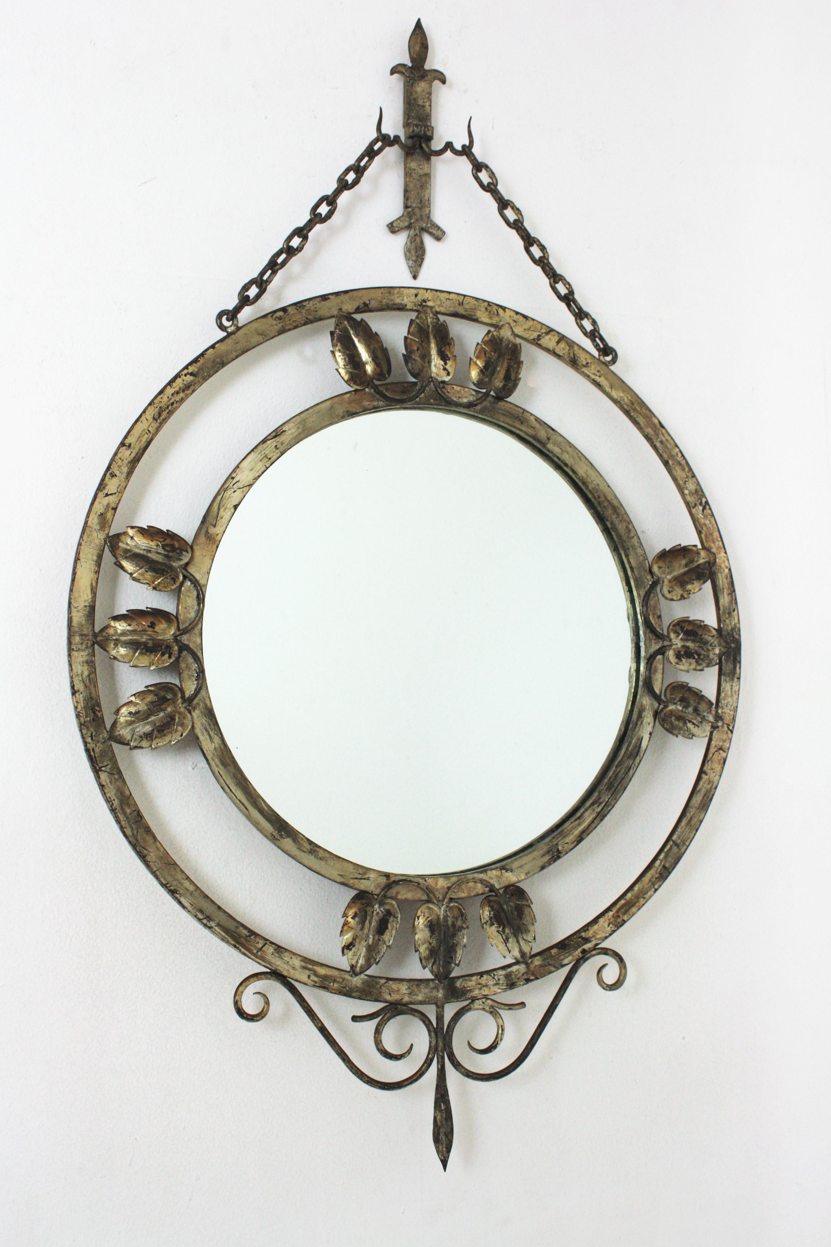 Silver Leaf gilt wrought iron round mirror with scroll and leaves details, France, 1940s.
Beautiful round hanging walll mirror. Elegant foliage design, hanging from two chains with decorative detail on top. It has a terrific aged patina showing the