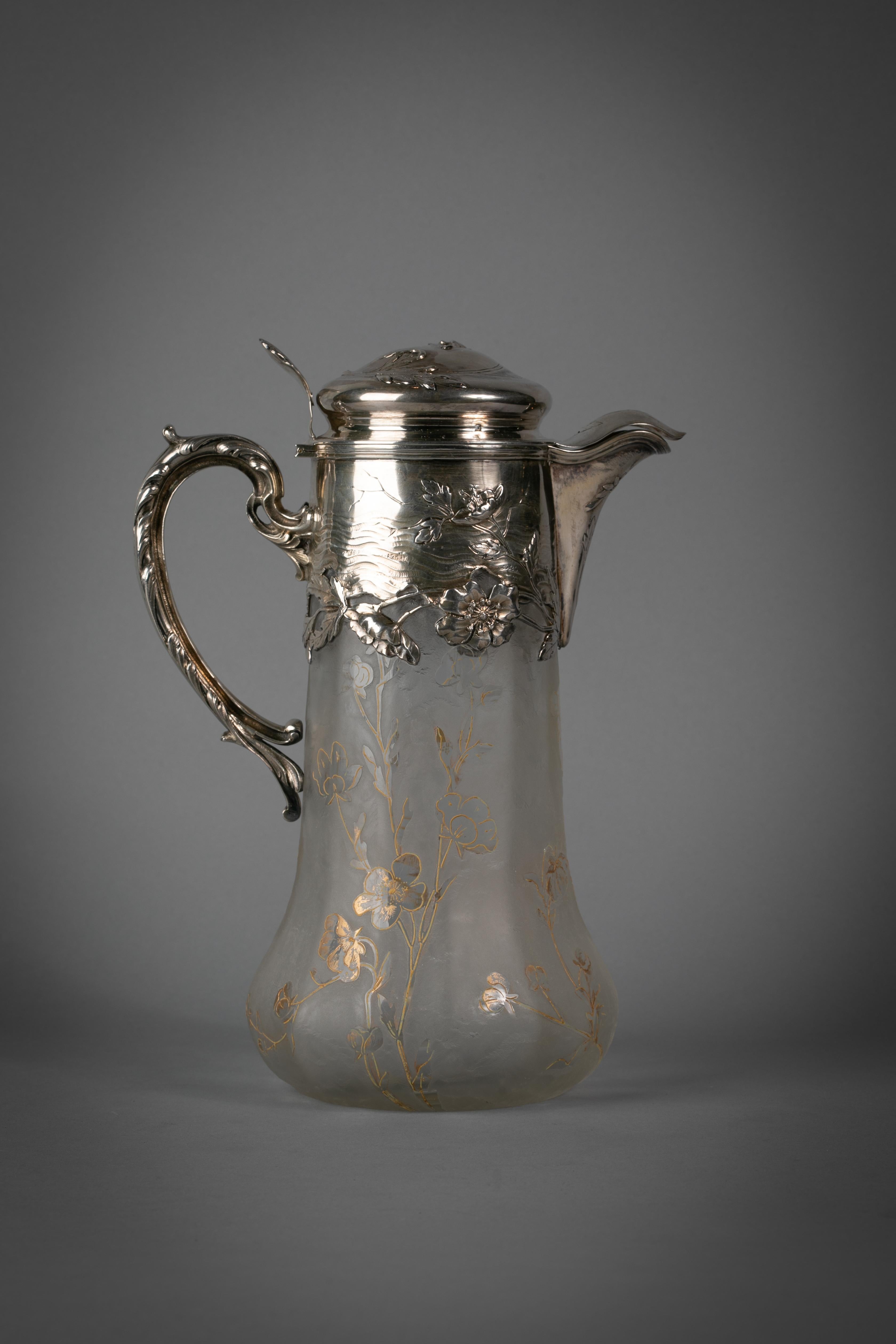 The silver mounts chased with Art Nouveau flowers and plants against a wavy background. The glass with a frosted background reserved in clear glass and gilt with a floral pattern. Silver marked.