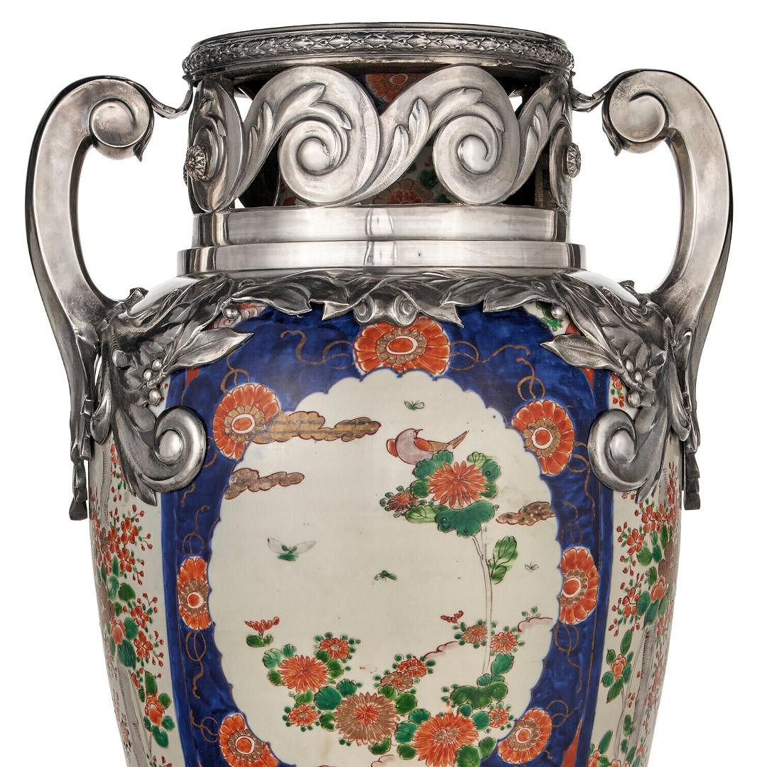 Our tremendous porcelain vase decorated in the Japanese Imari style with panels of birds and flowers in blue, green and orange/red is distinguished by its French silver mounts including circular foot and extensive decorations at the rim and shoulder