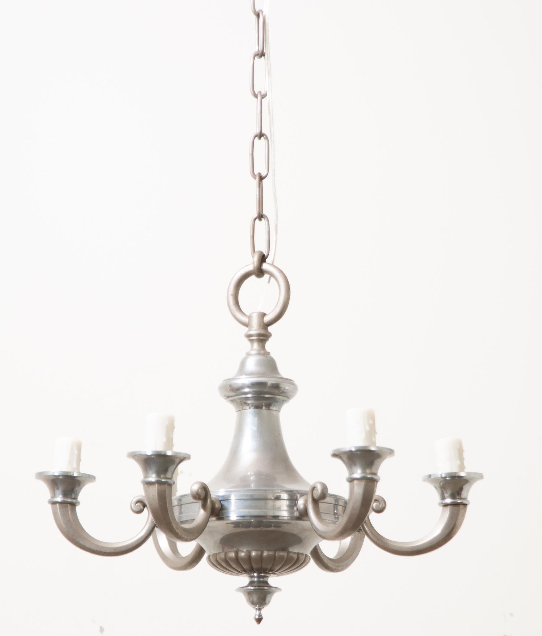 A classical French silver plate chandelier will add depth to any interior. The urn shaped fixture has 6 swooping candle arms each with faux candle covers to give ample, electrified light in your space. Be sure to view the detailed images to see the
