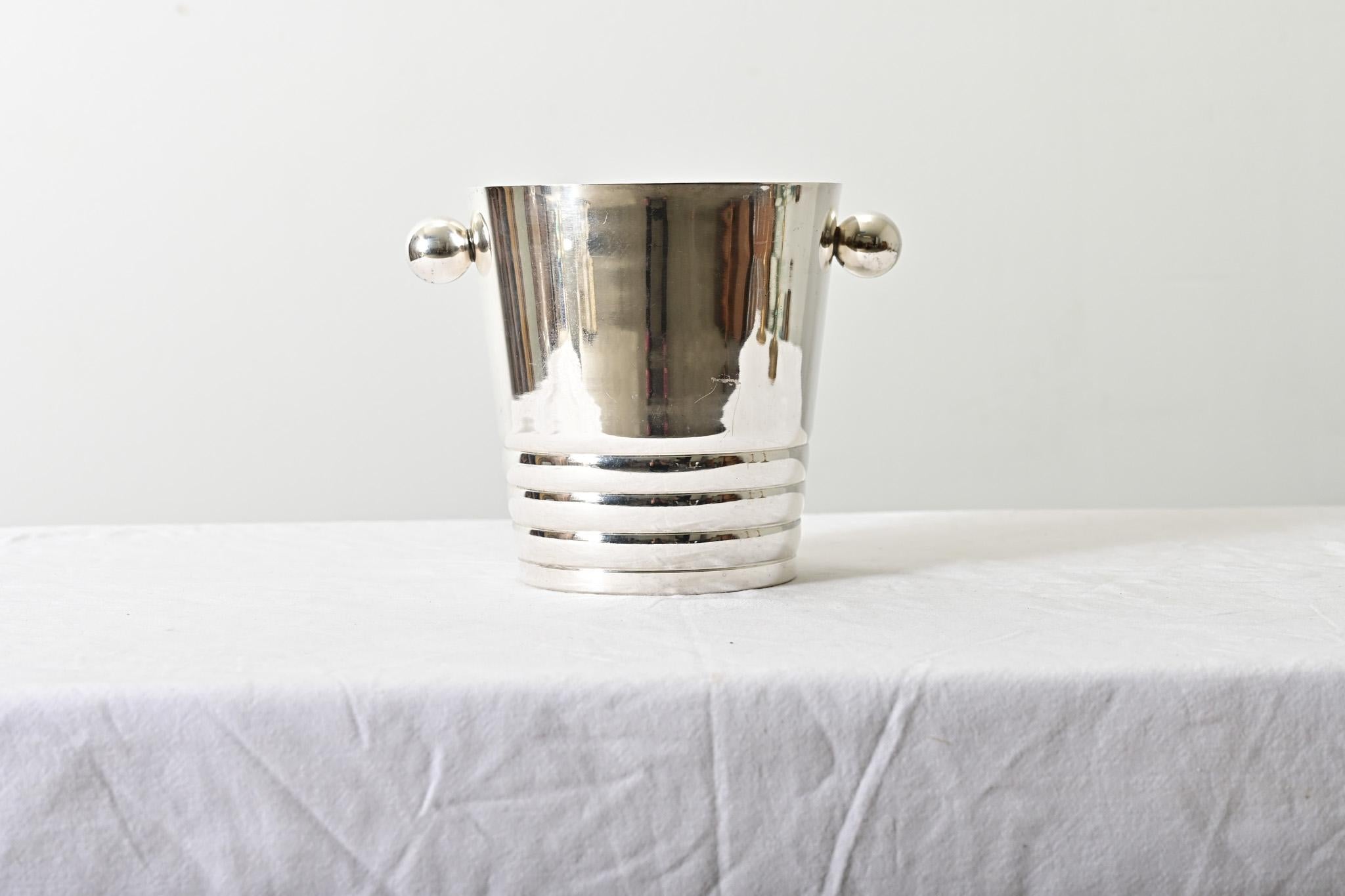 Un entretenimiento esencial para cualquier anfitrión, este Art Deco  La cubitera enfriadora de champán plateada de Francia será un accesorio duradero y fiable en todas las fiestas. Las grandes asas esféricas de los laterales permiten una
