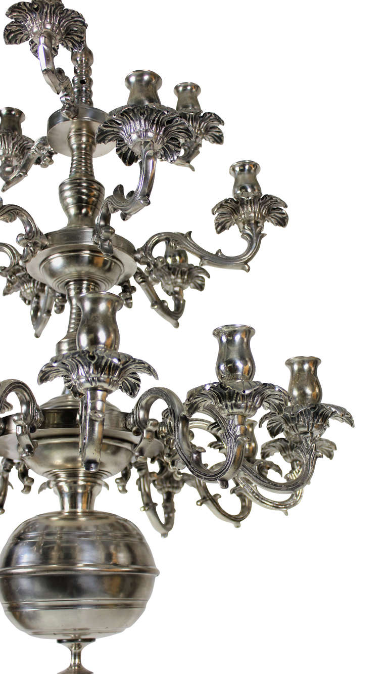 A large French, three-tier, twenty one branch silver plated chandelier. Of unusual design with foliate drip pans.
  