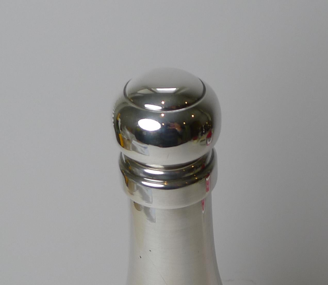 Ein seltener französischer Rezept-Cocktailshaker aus Silberblech in Form einer Champagnerflasche. Was dieses Exemplar so besonders und sammelwürdig macht, ist die eingravierte Halterung auf der Vorderseite, auf der sieben Cocktailrezepte mit