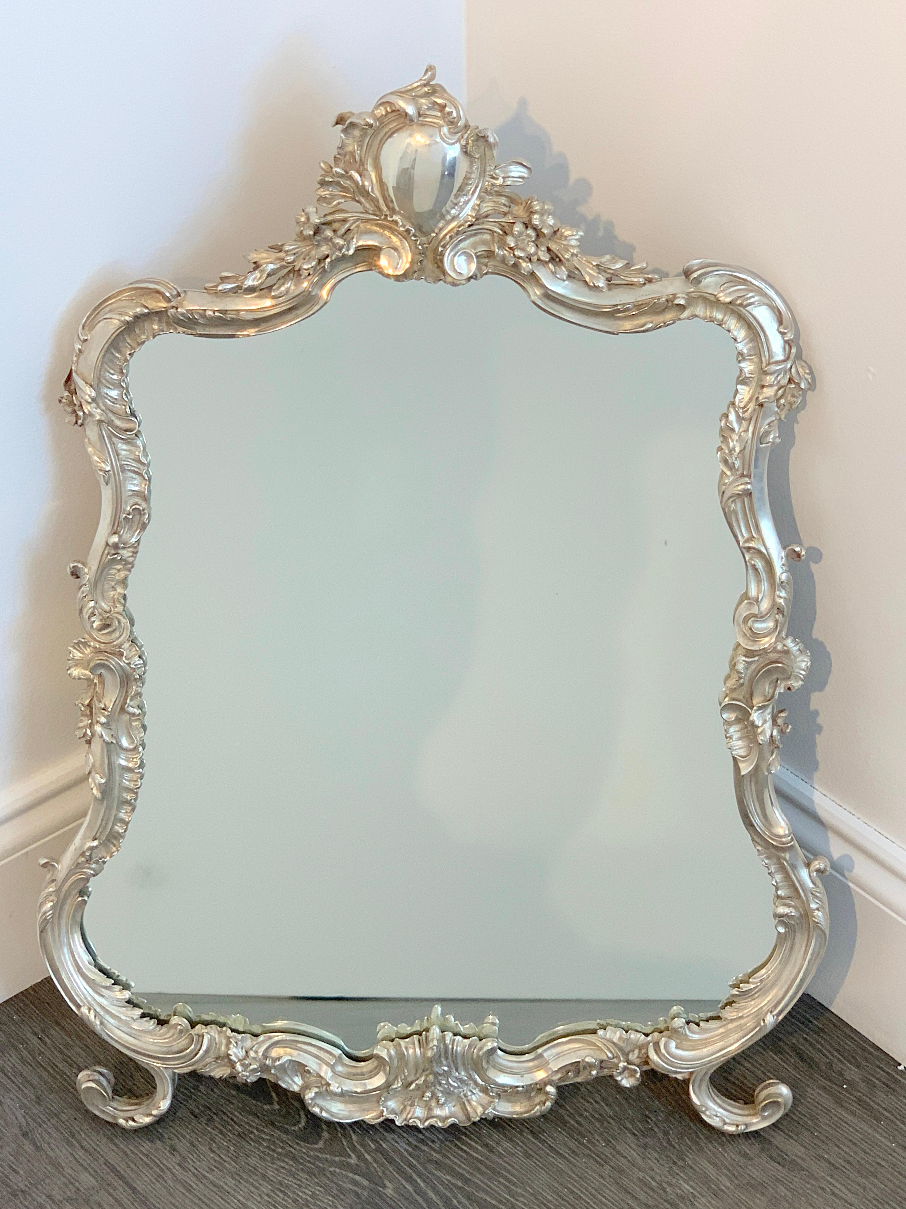 French silver plated dressing mirror, attributed to Christofle
Of cartouche shape with heavy, fine casting with chased florals, with new inset clear mirror, raised scroll feet. Unmarked.