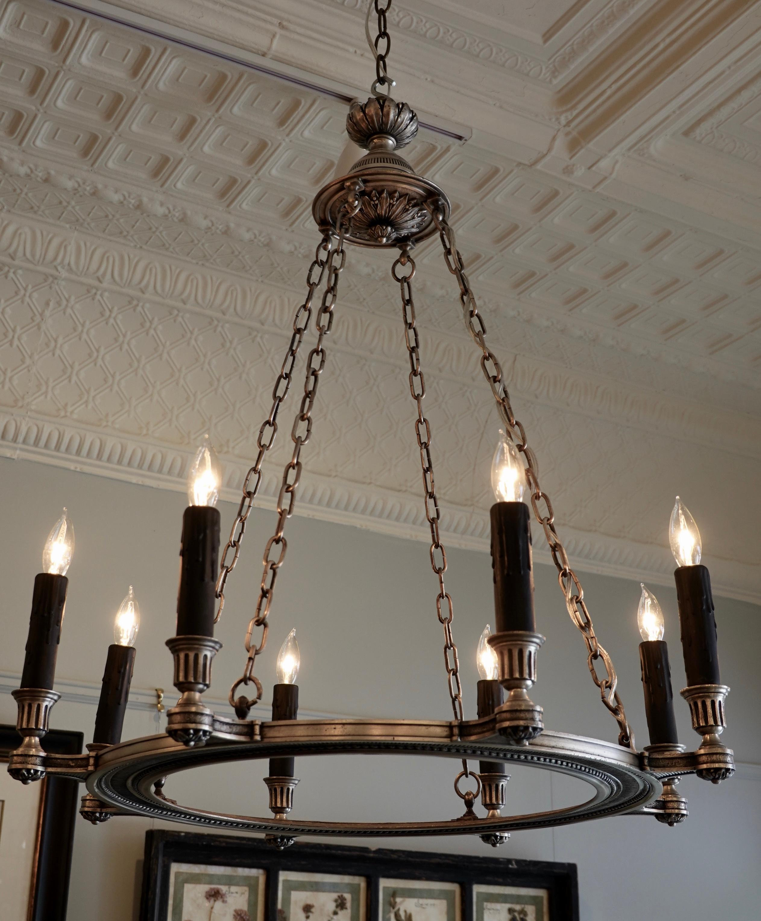 An elegant French silvered-bronze chandelier in the neoclassical style, suspended by four chains. The chandelier has be rewired with eight lights for the US. The frame features nicely chiseled details including rosettes, pearl beading and