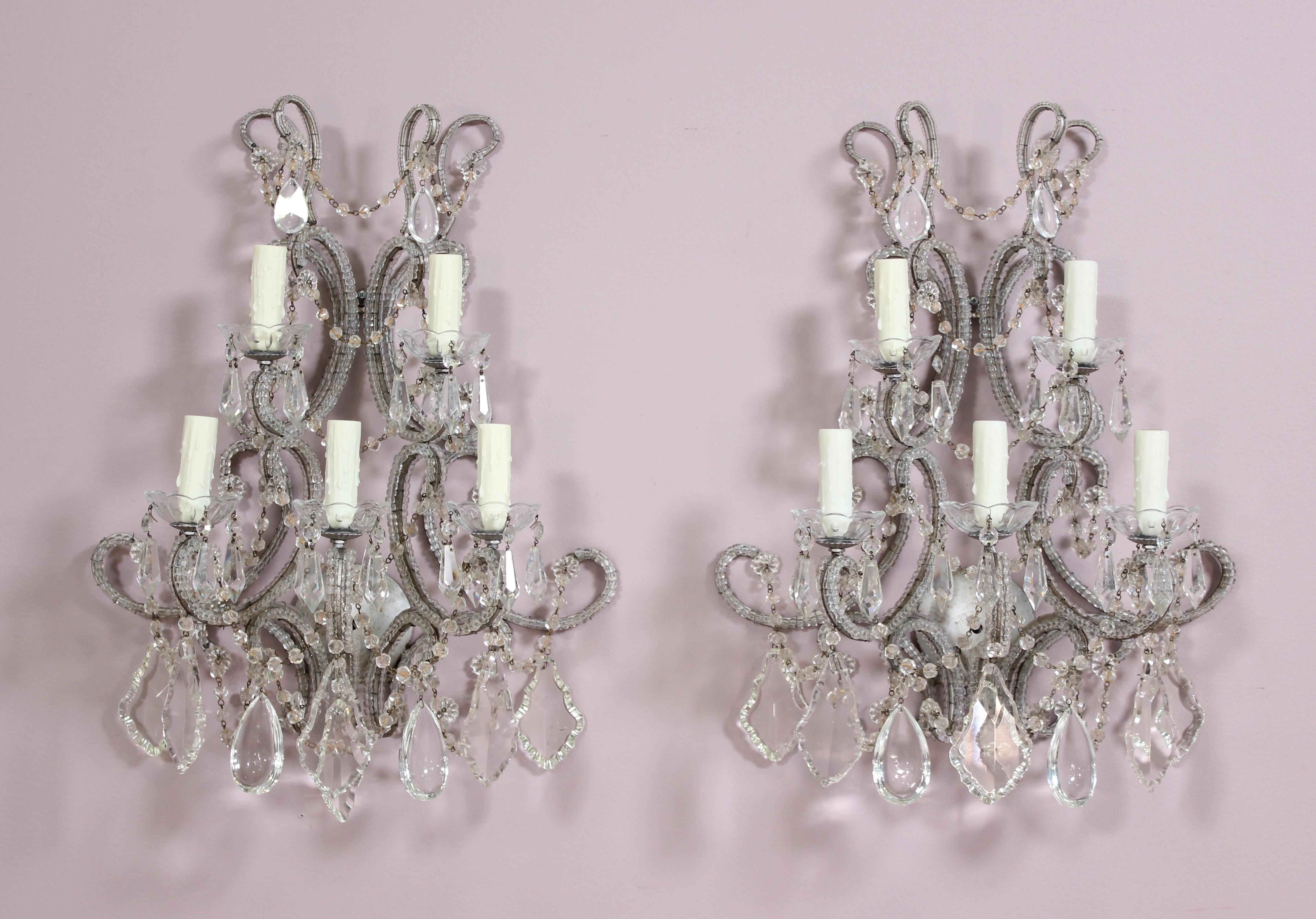 Impressive, pair of French-style crystal beaded and silver leafed iron sconces. These one of a kind sconces consist of both antique and new elements including glass “macaroni” glass beaded frames, English cut bead swags, and an assortment of French